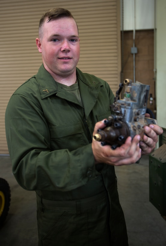 Lance Cpl. Gus O’Brien, an engineer equipment electrical systems technician, or generator mechanic, with Combat Logistics Company 11, Combat Logistics Regiment 15, holds a successfully detached fuel injector aboard Marine Corps Air Station Miramar, Calif., July 22. O’Brien is responsible for making repairs on generators for use in many different environments for different uses such as powering communications equipment, medical equipment, lights, air conditioning and heat as well as setting up airfields or ground refueling points. 