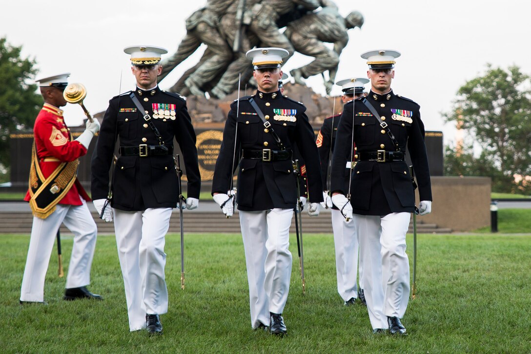 The Marine Barracks Washington, parade staff performs during a Tuesday Sunset Parade at the Marine Corps War Memorial in Arlington, Virginia, July 22, 2014.