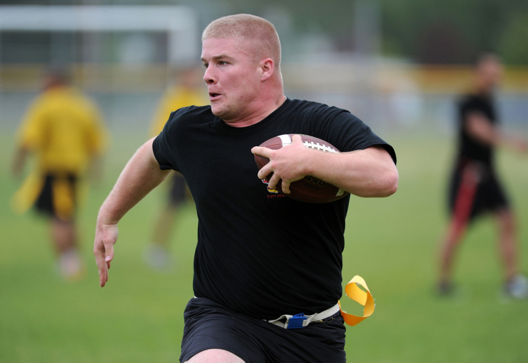Specialist Joshua Gomez, a native of Kings Mountain, N.C., assigned to the 2nd Battalion, 377th Parachute Field Artillery Regiment, 4th Infantry Brigade Combat Team (Airborne), 25th Infantry Division, U.S. Army Alaska, runs for a touchdown in a flag football game during "Steel Week" festivities on Joint Base Elmendorf-Richardson, Alaska, Thursday, July 17, 2014. "Steel Week" is an organizational week of sporting events culminating in a unit picnic for Soldiers and their dependants. (U.S. Air Force photo/Justin Connaher)