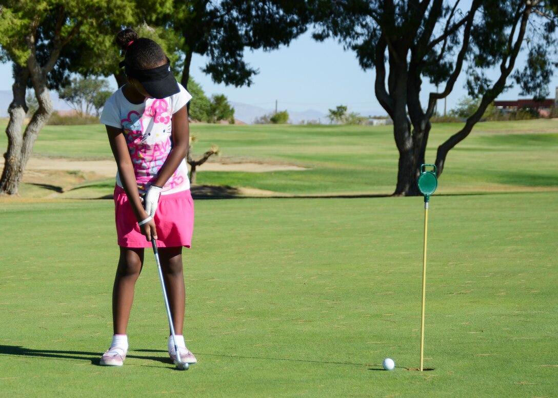 Nine-year-old Zahria, practices putting during the week-long children’s summer golf camp. (U.S. Air Force photo by Rebecca Amber)