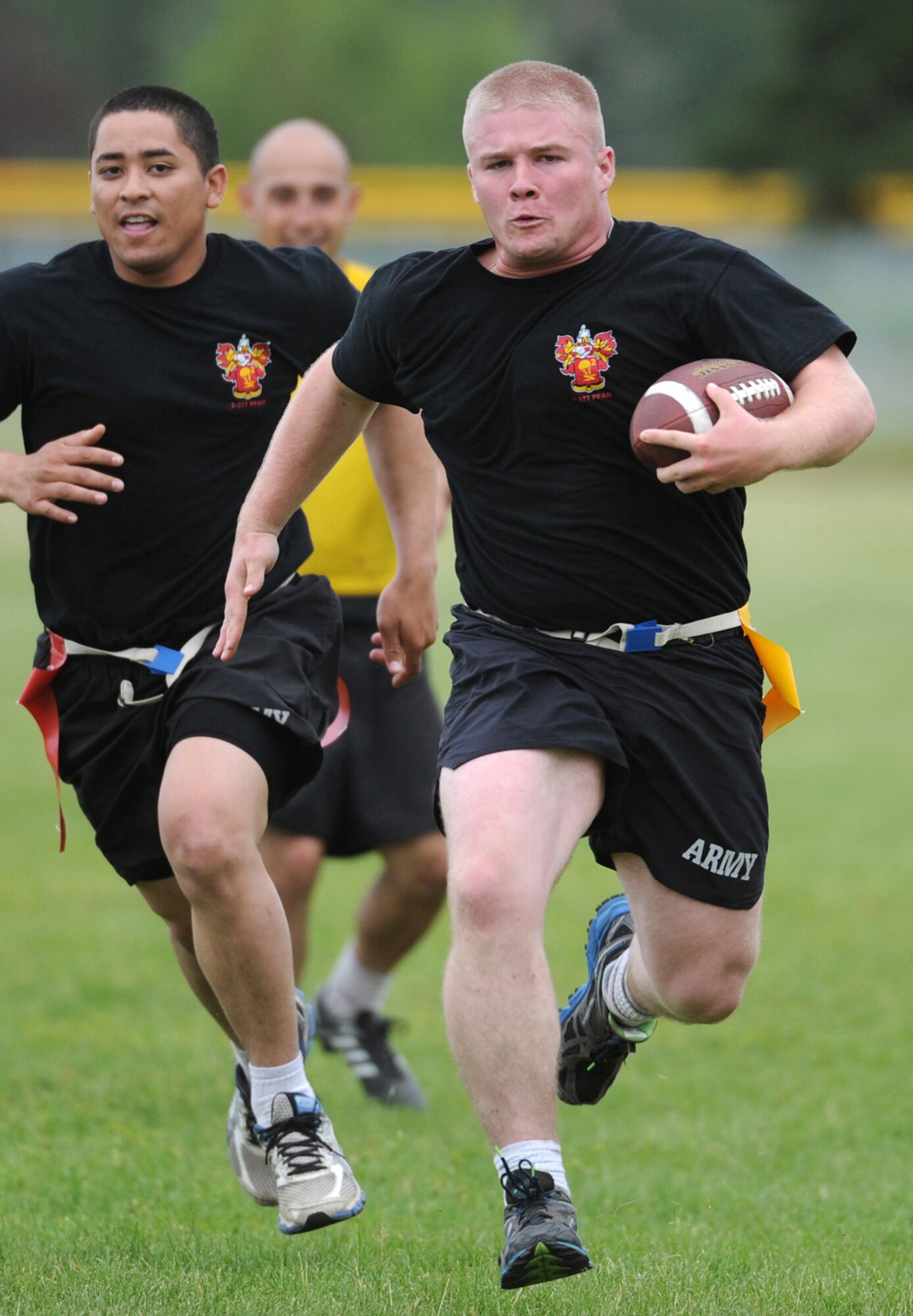 Specialist Joshua Gomez, a native of Kings Mountain, N.C., assigned to the 2nd Battalion, 377th Parachute Field Artillery Regiment, 4th Infantry Brigade Combat Team (Airborne), 25th Infantry Division, U.S. Army Alaska, runs for a touchdown in a flag football game during "Steel Week" festivities on Joint Base Elmendorf-Richardson, Alaska, Thursday, July 17, 2014. "Steel Week" is an organizational week of sporting events culminating in a unit picnic for Soldiers and their dependants. (U.S. Air Force photo/Justin Connaher)