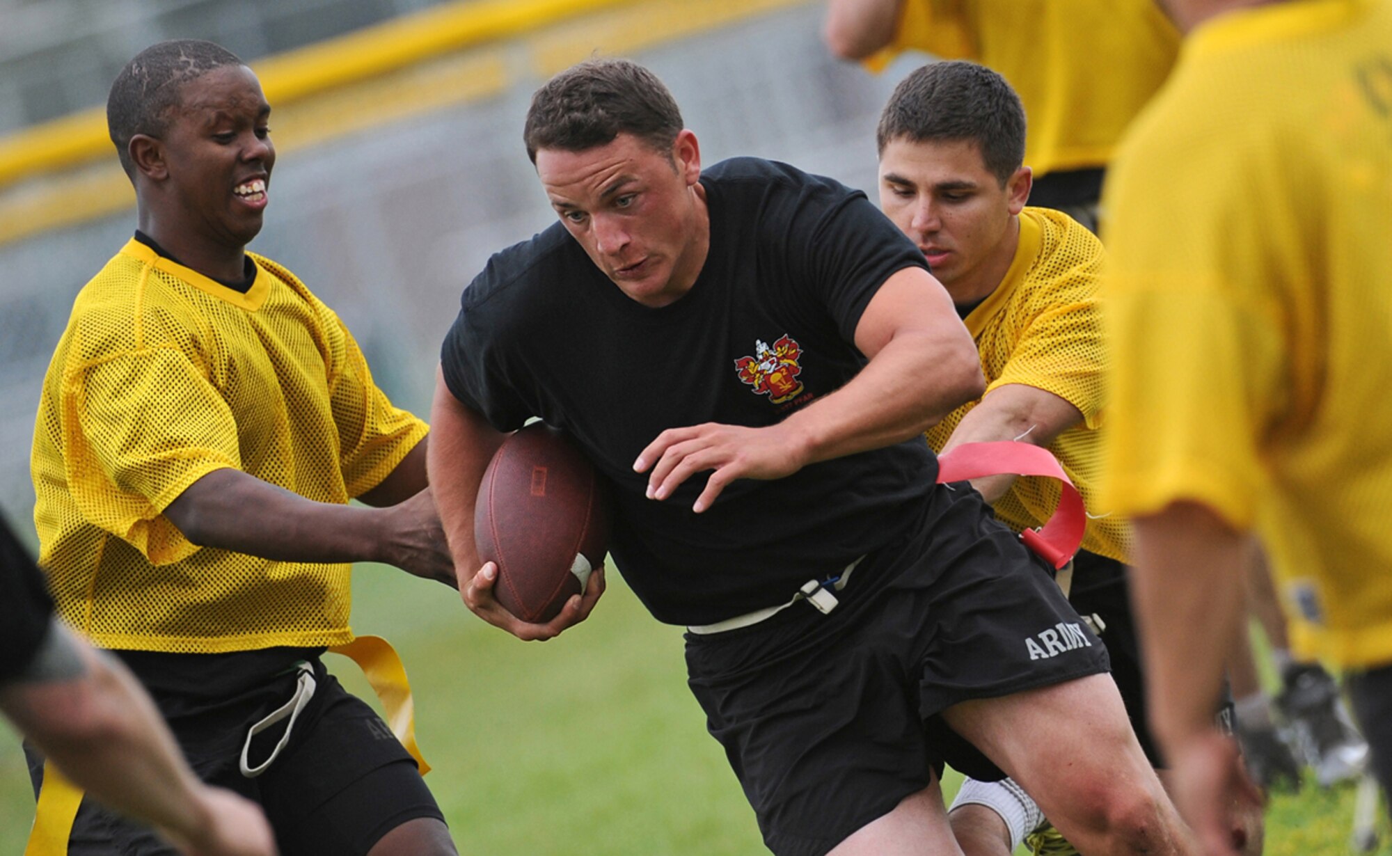 Specialist Brenden Dunleavy, a native of Ft. Myers, Fla., assigned to the 2nd Battalion, 377th Parachute Field Artillery Regiment, 4th Infantry Brigade Combat Team (Airborne), 25th Infantry Division, U.S. Army Alaska, breaks through a gap in defenders in a flag football game during "Steel Week" festivities on Joint Base Elmendorf-Richardson, Alaska, Thursday, July 17, 2014. "Steel Week" is an organizational week of sporting events culminating in a unit picnic for Soldiers and their dependants. (U.S. Air Force photo/Justin Connaher)