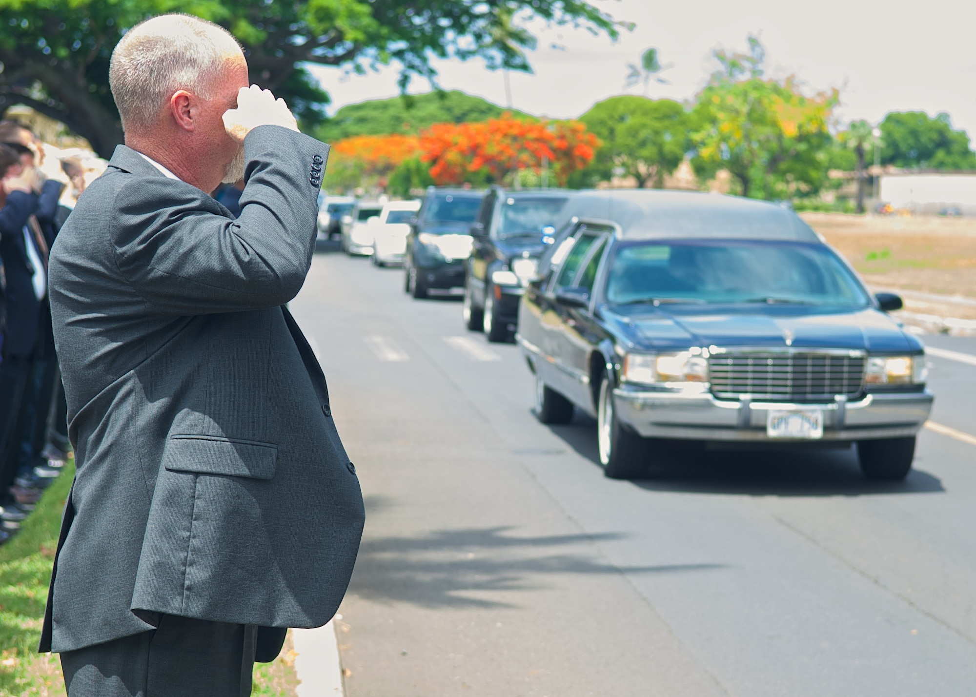 Special Agent Timothy Ries, Office of Special Investigations Region Six deputy director, salutes a convoy of vehicles transporting the remains of Col. Eugene Smith from the Joint POW/MIA Accounting Command facility on Joint Base Pearl Harbor-Hickam, Hawaii July 22, 2014. While flying to Elmendorf Air Force Base in November 1952, Smith was lost when his Douglas C-124 Globemaster II crashed into the side of Mt. Gannet in Alaska. The lost crash site was recently found by the Alaska Air National Guard. Smith will be brought home to Delaware via military dignified transfer July 24, 2014 and will receive a burial with full military honors. (U.S. Air Force photo by Tech. Sgt. James Stewart/Released)