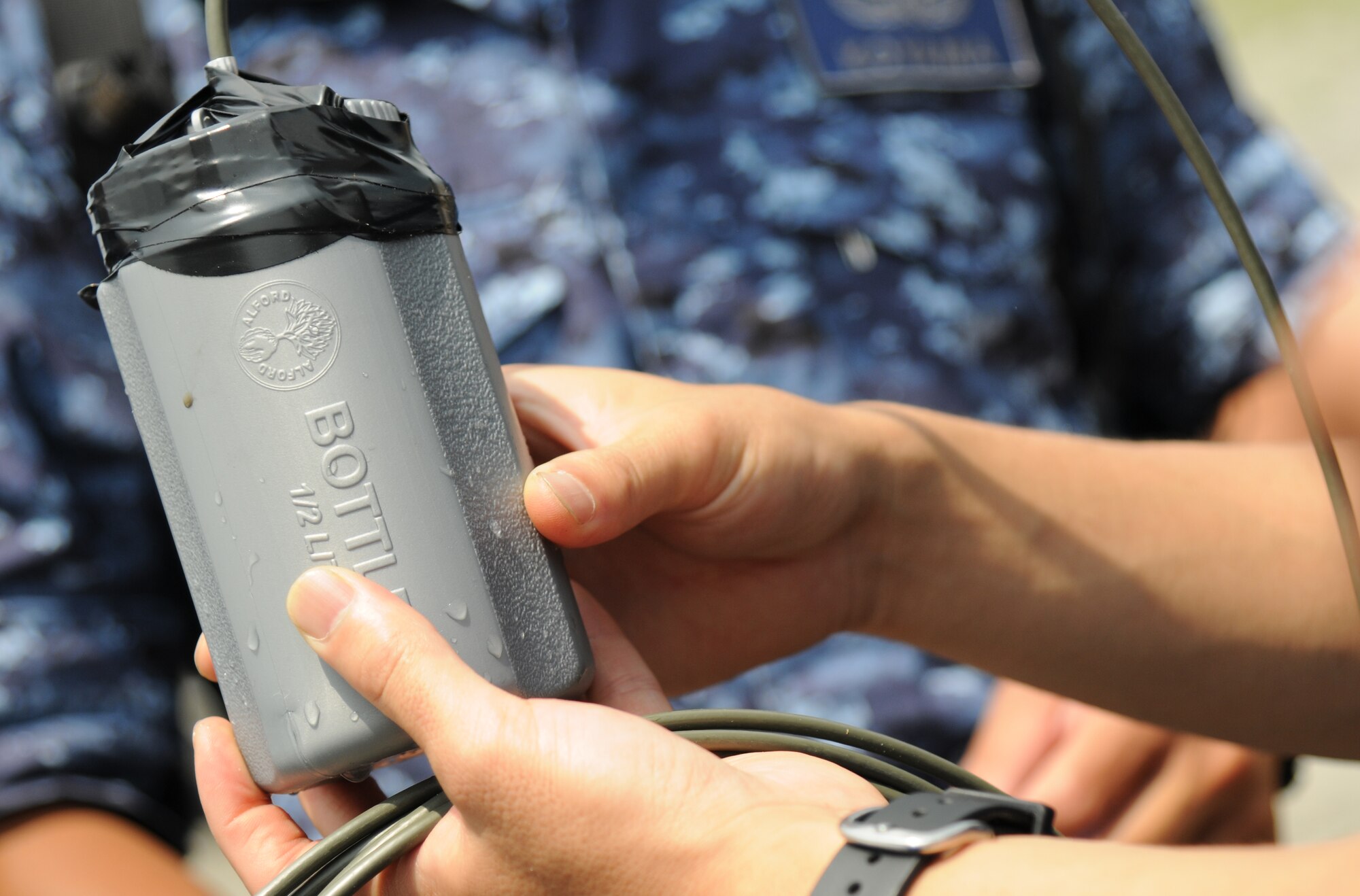 An explosive device is handled by a member of the Japanese Maritime Self-Defense Forces during a joint, bilateral exercise at the Draughon Bombing Range, Misawa Air Base, Japan, July 15, 2014. JMSDF EOD members had the opportunity to witness how U.S. military EOD members gain access to vehicles suspected as improvised explosive devices. (U.S. Air Force photo/Senior Airman Jose L. Hernandez-Domitilo)