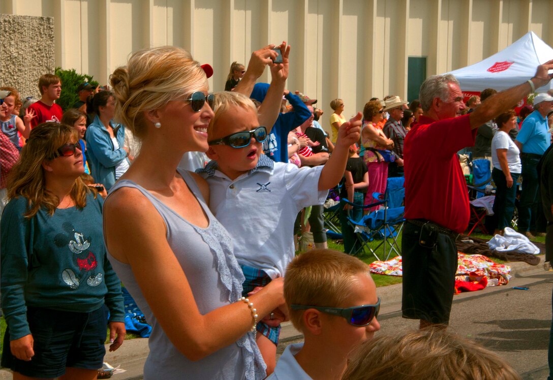 140723-F-BR137-120 Erin Martin and her son Killian, 3, Cheyenne residents, track the U.S. Air Force Thunderbirds through the sky July 23 during an air show above the skies of Cheyenne, Wyo. Crowds of people visiting the city during Cheyenne Frontier Days came out to Laramie County Community College to see the Thunderbirds perform. (U.S. Air Force photos by Airman 1st Class Jason Wiese)