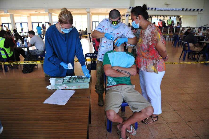 Australian and Tongan dental personnel perform an extraction on a patient during the healthcare services outreach, Neiafu, Vava'u, July 22, 2014. The HSO dental clinic supplemented services provided by the local hospital during Pacific Angel-Tonga. Dental personnel performed basic exams and extractions. (U.S. Air Force photo by Staff Sgt. Rachelle Coleman/Released)