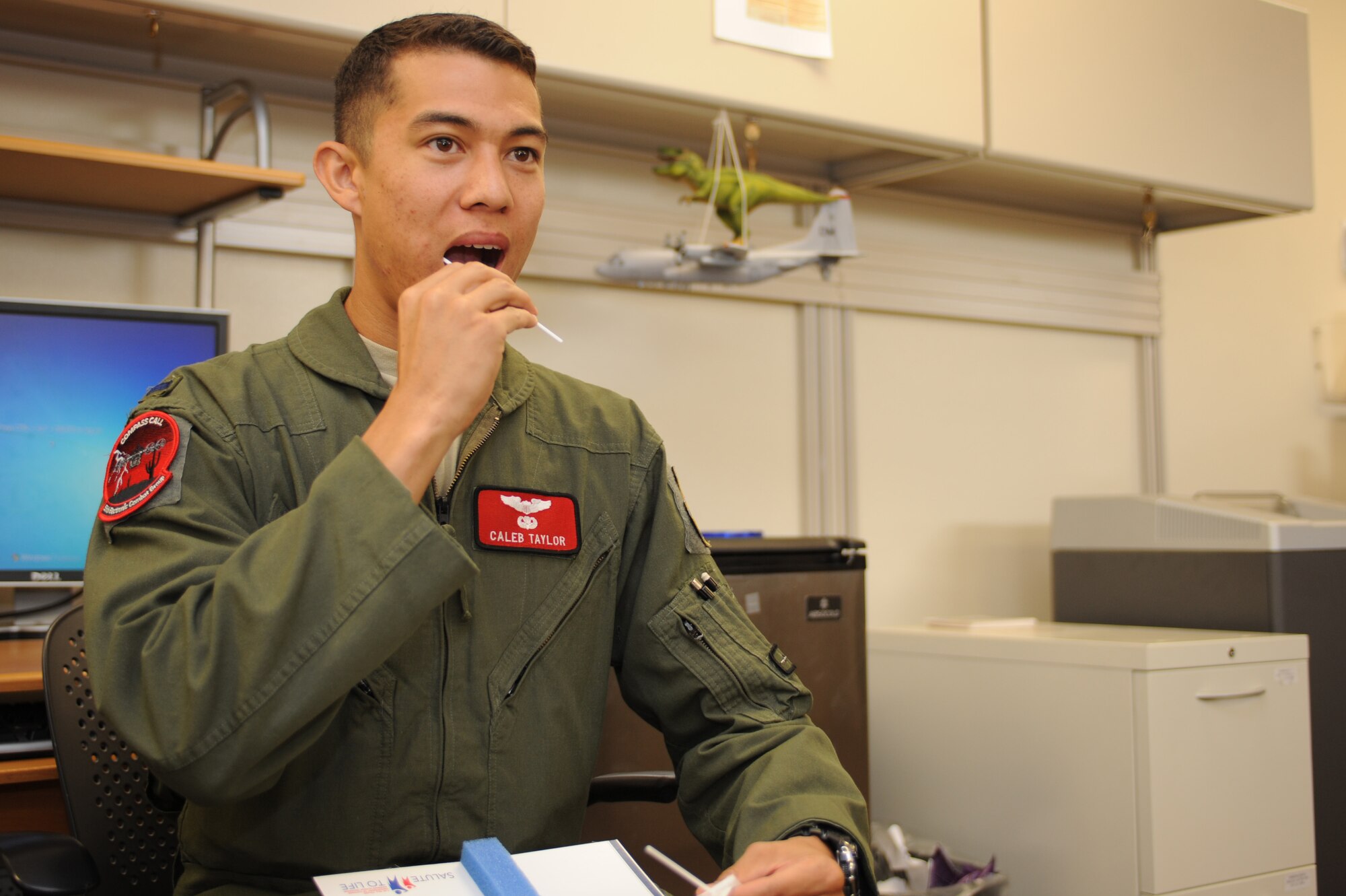 U.S. Air Force 1st Lt. Caleb Taylor, 55th Electronic Combat Group deputy group resource advisor and standardization and evaluation liaison officer, swabs the inside of his cheek at Davis-Monthan Air Force Base, Ariz., July 22, 2014. Taylor was required to submit a swab sample in order to register as a bone marrow donor.  (U.S. Air Force photo by Airman 1st Class Cheyenne Morigeau/Released)