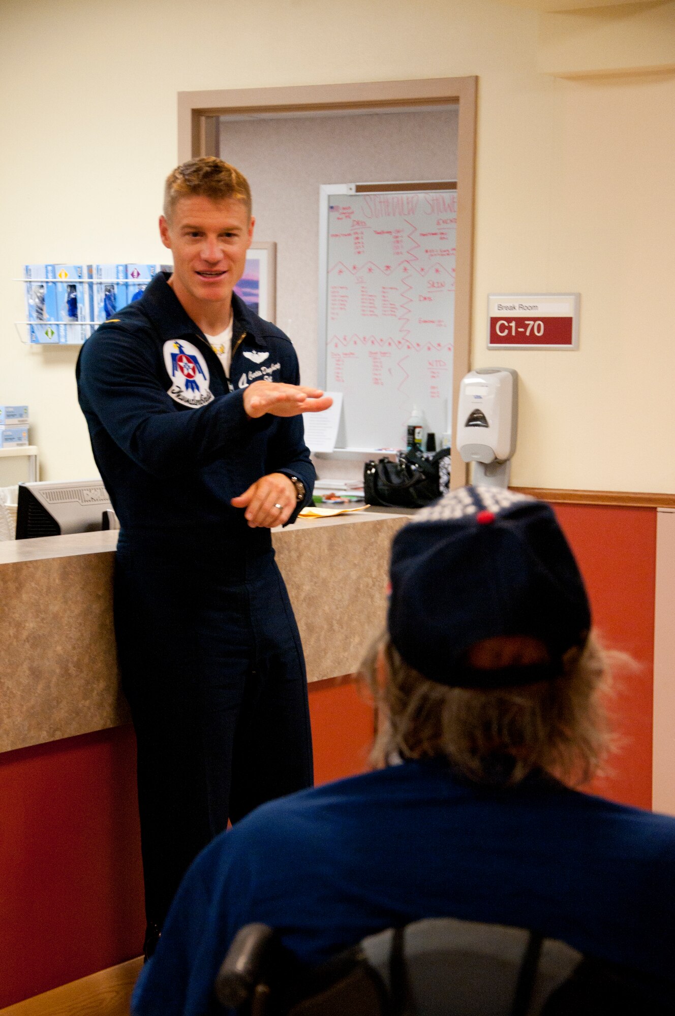 Maj. Curtis Dougherty, U.S. Air Force Thunderbirds #4 slot pilot, converses with a Cheyenne Veterans Affairs Medical Center patient July 22, 2014. Dougherty and fellow Thunderbirds, Maj. Michael Carletti, flight surgeon; Master Sgt. Thad Smith,  recruiter; Staff Sgt. Stan Weaver, #4 dedicated crew chief; and Staff Sgt. Jess Rivers, #4 assistant dedicated crew chief, visited the medical center to get a chance to interact with the veterans there. It was a great opportunity for the Thunderbirds to meet men and women who served in the U.S. military before them. (U.S. Air Force photo by Airman 1st Class Jason Wiese)