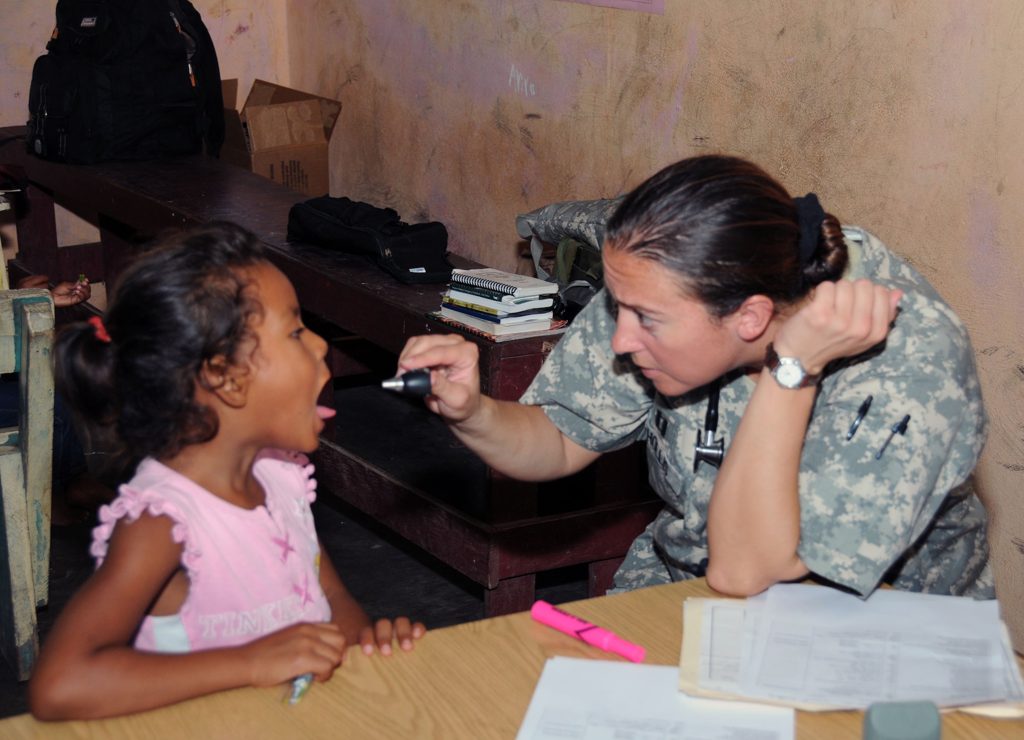 U. S. Army Capt. Emily Hollis examines a Honduran child during a MEDRETE.  Joint Task Force -Bravo's Medical Element (MEDEL), with support from 1-228th Aviation Regiment, JTF-Bravo Joint Security Forces and Army Forces Battalion, partnered with the Honduras Ministry of Health and the Honduran military to provide medical care to more than 650 people in the remote village of Barra Patuca in the Department of Gracias a Dios, Honduras, during a Medical Readiness Training Exercise (MEDRETE), July 17, 2014.  The multi-national team worked together to provide preventative medicine to the villagers, including classes on hygiene, preventative dental care, and nutrition. They also provided immunizations to infants, dental care, wellness checkups, medications, and minor medical procedures.  (Photo by U. S. Air National Guard Capt. Steven Stubbs)