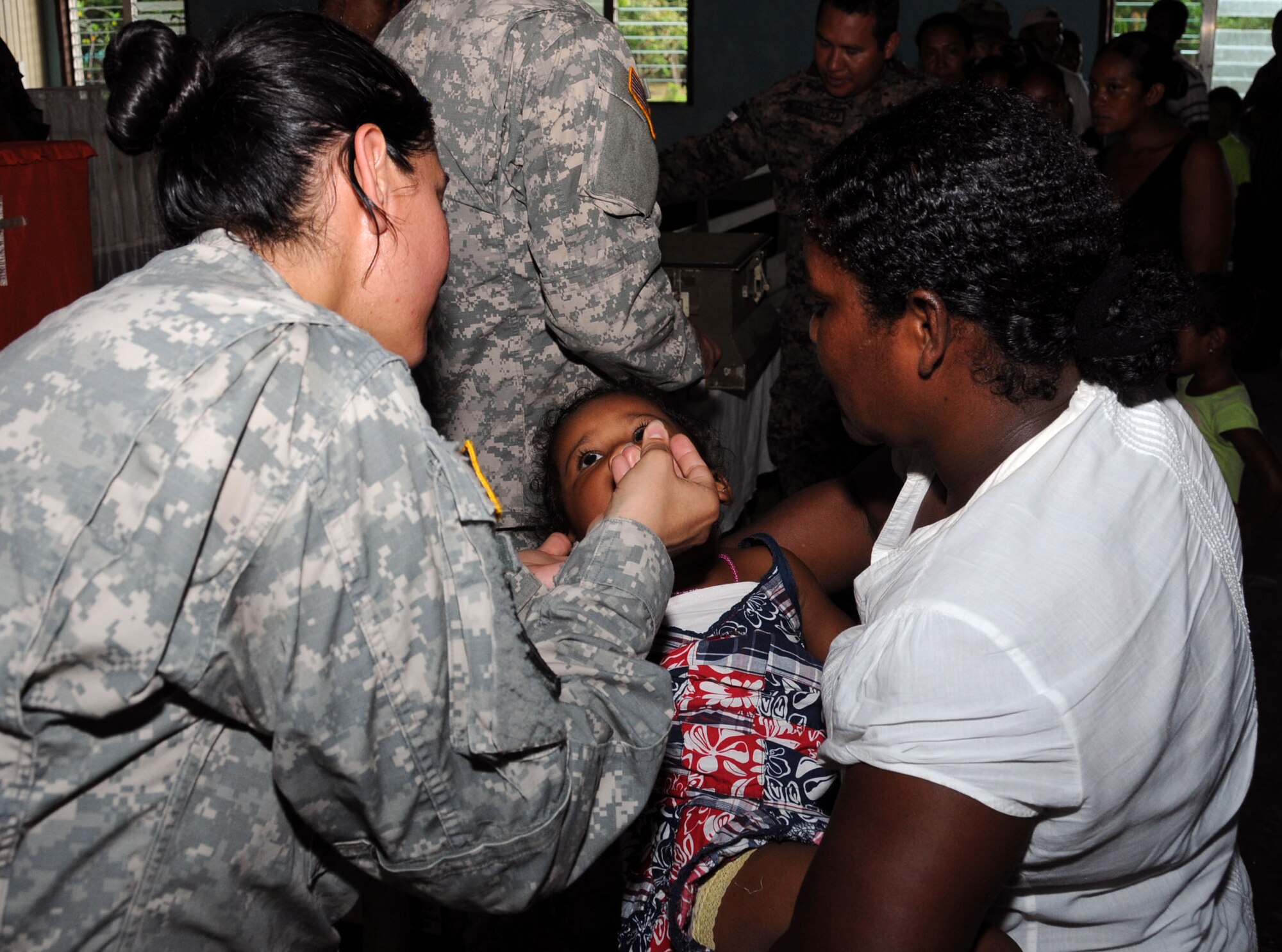 A Honduran child receives de-worming medication from a MEDEL service member during a MEDRETE.  Joint Task Force -Bravo's Medical Element (MEDEL), with support from 1-228th Aviation Regiment, JTF-Bravo Joint Security Forces and Army Forces Battalion, partnered with the Honduras Ministry of Health and the Honduran military to provide medical care to more than 650 people in the remote village of Barra Patuca in the Department of Gracias a Dios, Honduras, during a Medical Readiness Training Exercise (MEDRETE), July 17, 2014.  The multi-national team worked together to provide preventative medicine to the villagers, including classes on hygiene, preventative dental care, and nutrition. They also provided immunizations to infants, dental care, wellness checkups, medications, and minor medical procedures.  (Photo by U. S. Air National Guard Capt. Steven Stubbs)