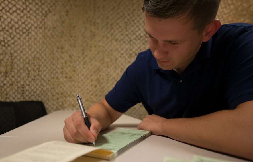 U.S. Air Force Senior Airman James Reed III, 23d Contracting Squadron contracting officer, fills out a simulated Standard Form 44 at Moody Air Force Base, Ga., July 22, 2014. An SF 44 is a purchase order invoice that enables contracting officers to obligate the government to distribute funds to vendors. (U.S. Air Force photo by Airman Dillian Bamman/Released)
