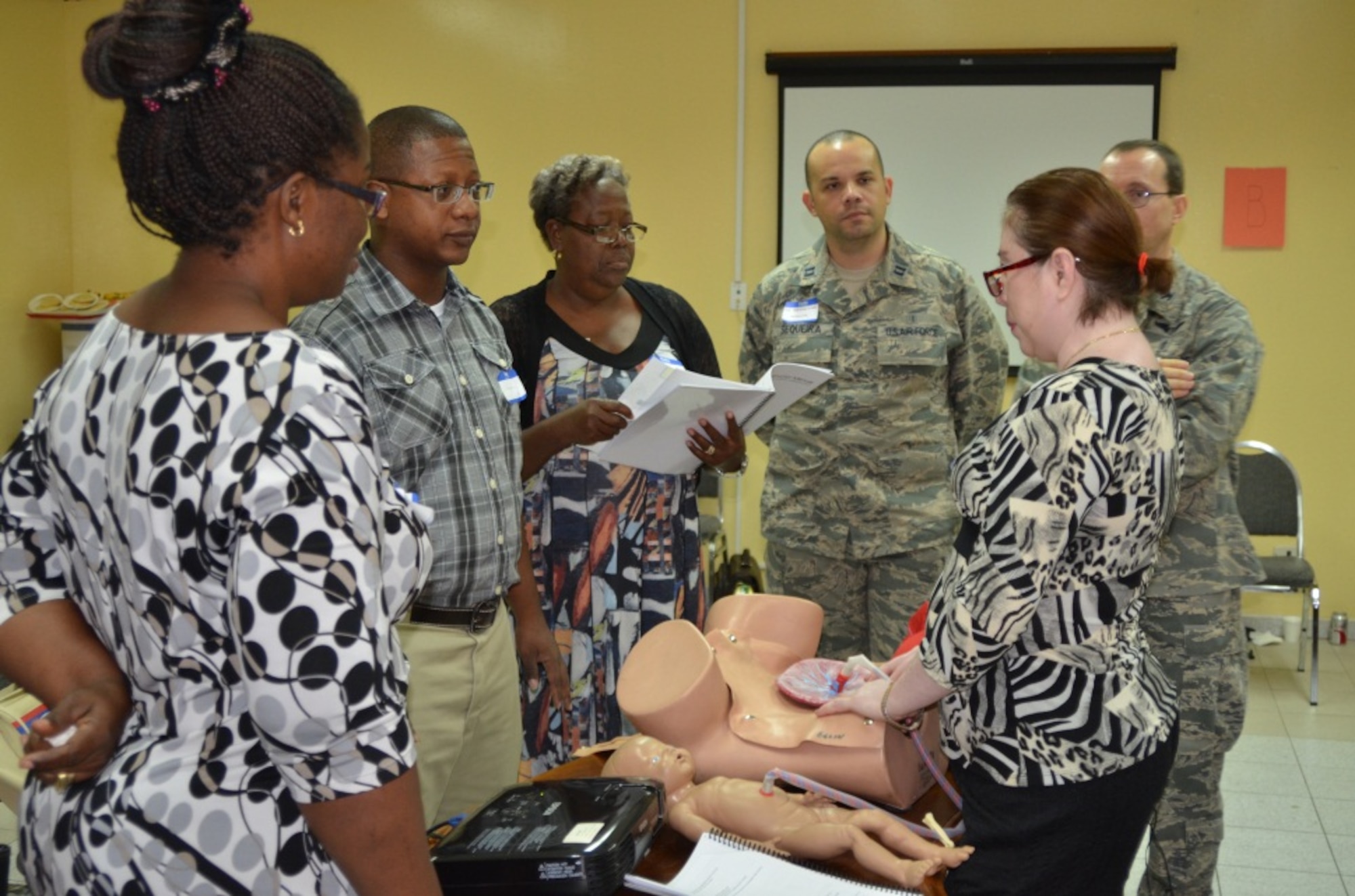 Belizean healthcare providers Uchenna Obasi, Dr. Desmond Arzu, Matron Matilda Mark and Rosanna Herstig practice group teaching at the Global ALSO Instructor Course, while Capt. Ricardo Sequeria and Col. Lyrad Riley, health care providers assigned to the 96th Medical Operations Squadron at Eglin AFB, monitor their progress  during the course in Belize City, Belize, June 22, 2014.  (Courtesy Photo) 