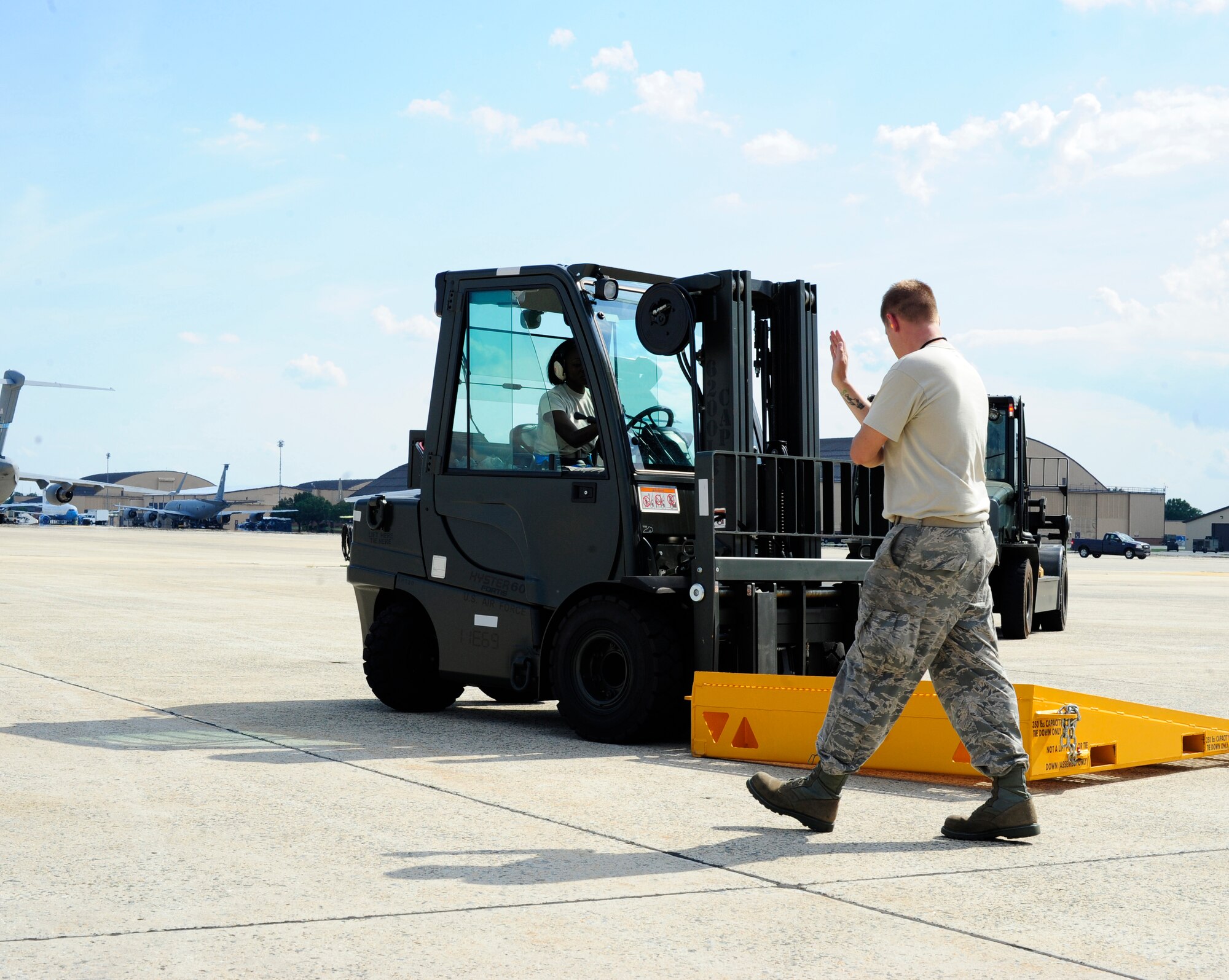 Airman 1st Class Gelisha Jones (driving forklift) and Staff Sgt. Ryan Osinski, both air transportation specialists from the 89th Aerial Port Squadron place ramps on a specially modified C-5 Galaxy in preparation to unload a massive piece of NASA’s James Webb Space Telescope at Joint Base Andrews, Md., July 17, 2014. Crews from the 89th APS, 22nd Airlift Squadron out of Travis Air Force Base, Calif., and NASA’s Goddard Space Flight Center in Greenbelt, Md., worked together to deliver the cargo. (U.S. Air Force photo/U.S. Air Force photo/Staff Sgt. Torey Griffith)