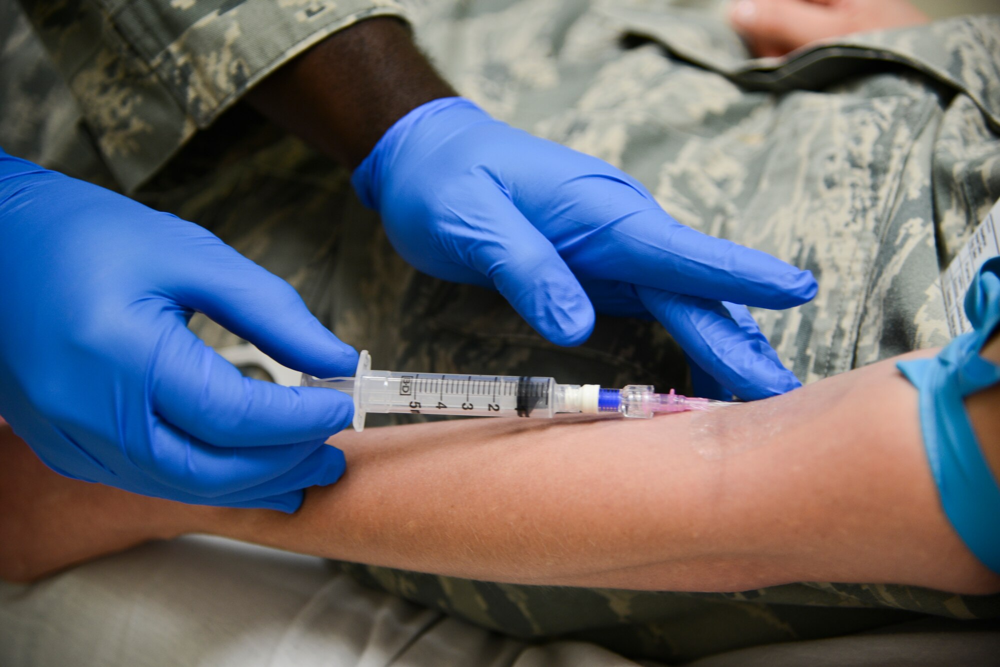 U.S. Air Force Reserve Senior Airman Akwasi Agyemang, 445th Aeromedical Staging Squadron medical technician, presses an intravenous needle against the arm of Reserve Airman 1st Class Saschia Johnson, 445th Aerospace Medicine Squadron medical technician, for a training simulation during their tour at USAF Hospital Langley at Langley Air Force Base, Va., July 21, 2014. Agyemang is completing biannual refresher training at the hospital to ensure he is fully qualified to deploy if called upon. (U.S. Air Force photo by Airman 1st Class Devin Scott Michaels/Released)