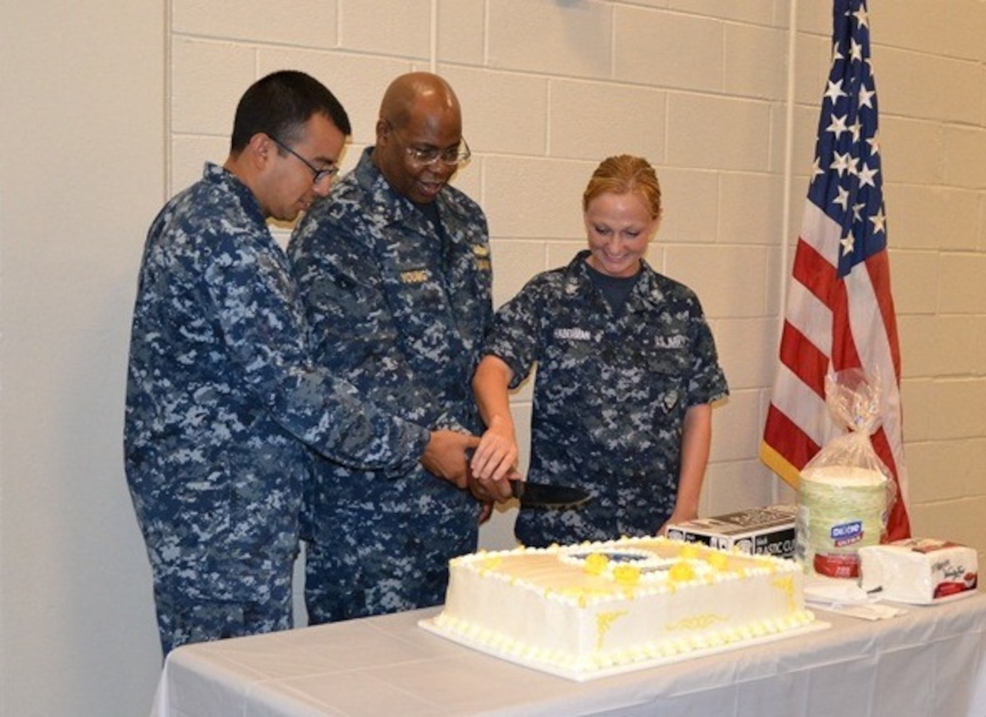 Rear Adm. Eric Young, deputy chief of Navy Reserve, center,
participates in a cake cutting ceremony with Petty Officers 2nd Class James
Rivas and  Megan Haberman as part of the Navy Operational Support Center
Charleston celebration July 12, 2014 at Joint Base Charleston, S.C. (Courtesy photo)
