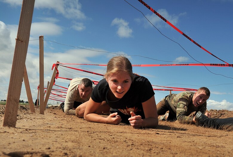 Marc Caughey (left, background), Rebecca Westing (foreground), and Matthew Lintker, 50th Space Wing Command Section Team, crawl through an obstacle during the Schriever Rough and Tough Scramble July 17, 2014, at Schriever Air Force Base, Colo. More than 100 racers participated in the event. (U.S. Air Force photo/Dennis Rogers)