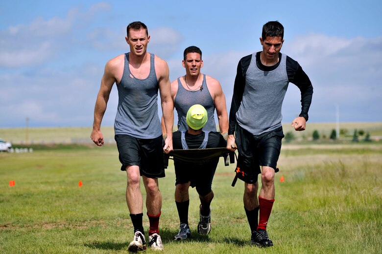 Participants carry a litter as one of the obstacles during the Schriever Rough and Tough Scramble July 17, 2014, at Schriever Air Force Base, Colo. More than 100 racers participated in the event. (U.S. Air Force photo/Dennis Rogers)