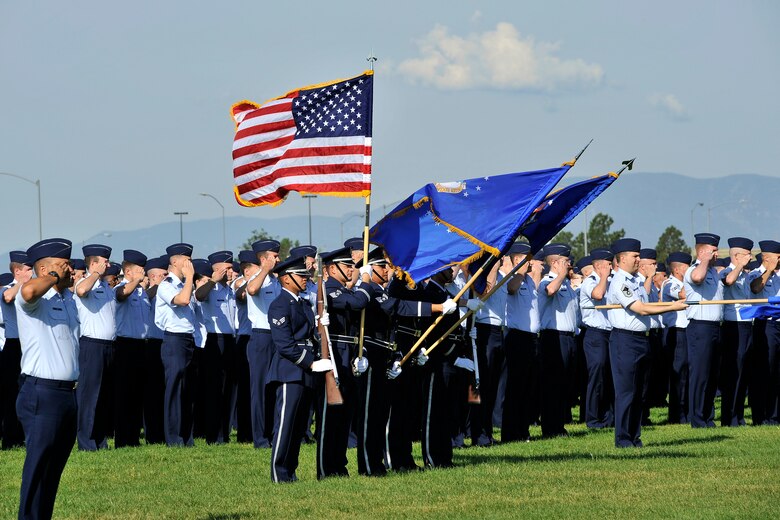 Airmen pay their respects to the Stars and Stripes during reveille July 14, 2014, at Schriever Air Force Base, Colo., as part of the Schriever Week opening ceremony. The base held a weeklong celebration to honor the installation's history and recognize the people who support the mission. (U.S. Air Force photo/Dennis Rogers)