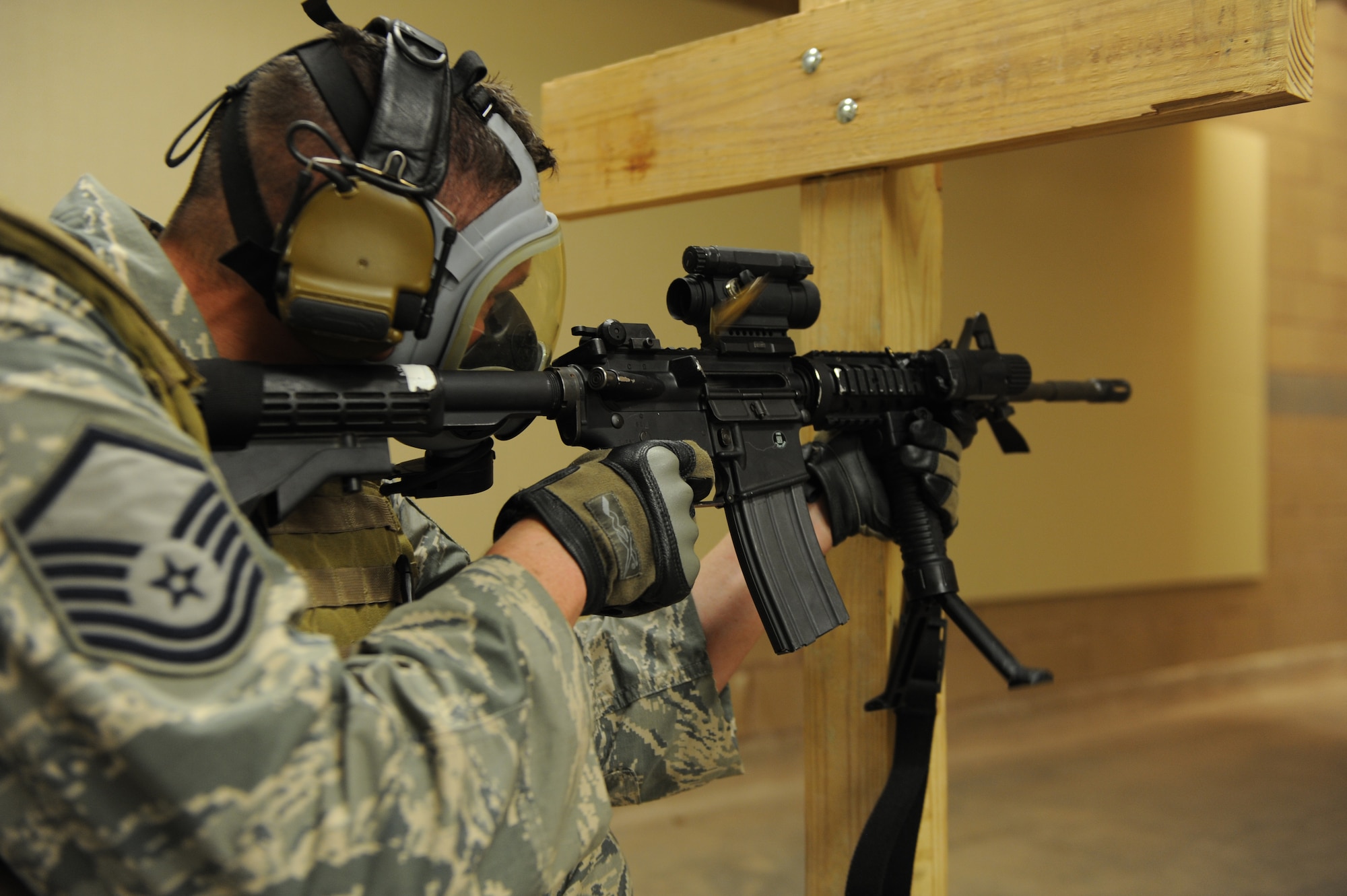 U.S. Air Force Master Sgt. James Dillard, 7th Security Forces fires an M4 carbine at the new indoor range July 18, 2014, at Dyess Air Force Base, Texas. It is required for qualification to fire a portion of the course while wearing a gas mask. (U.S. Air Force photo by Airman 1st Class Alexander Guerrero/Released)