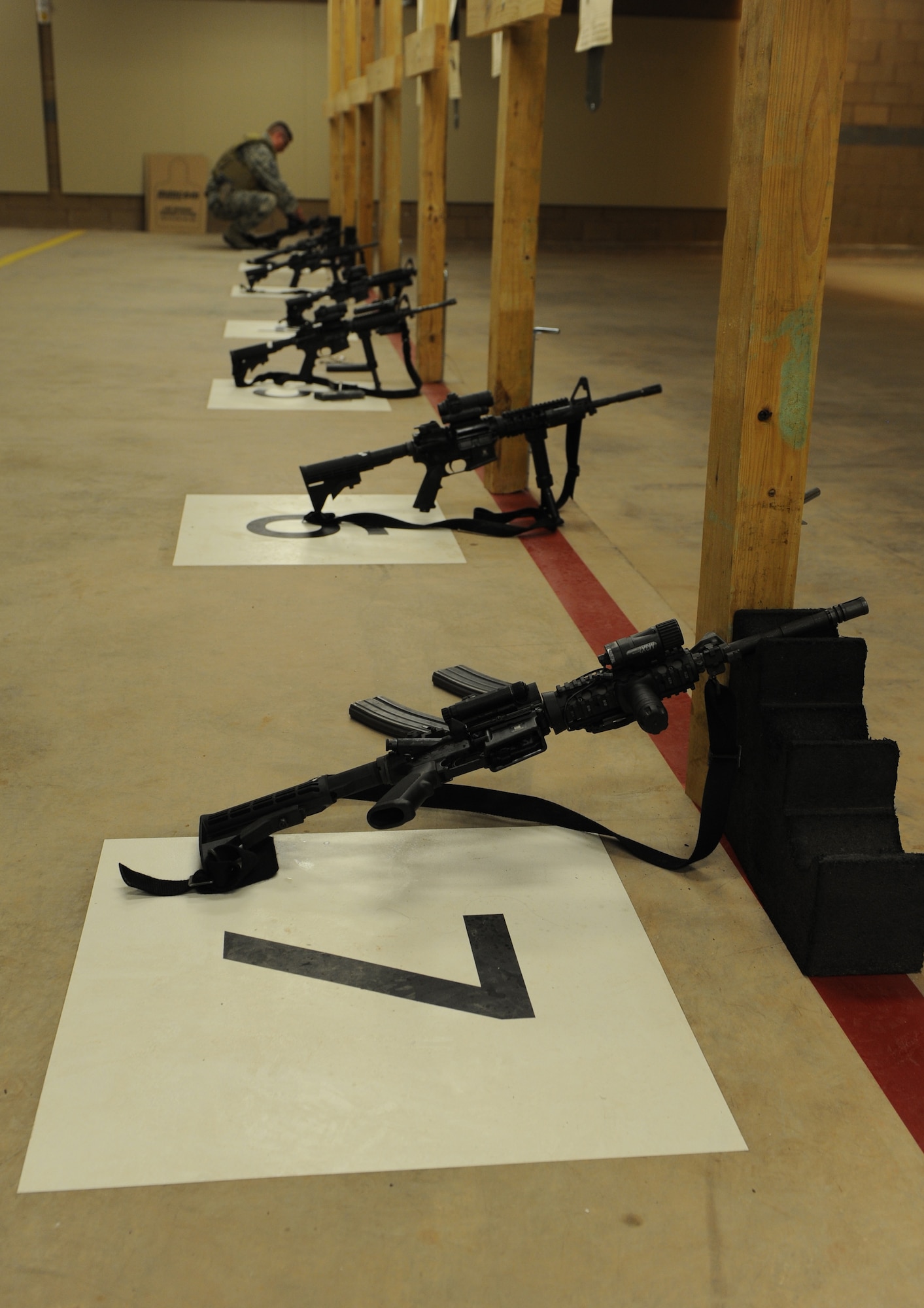 M4 carbines lay on the firing line in the indoor firing range before a qualification shoot July 21, 2014, at Dyess Air Force Base, Texas. Airmen must use several different courses of fire, both timed and untimed, to qualify on the M4. (U.S. Air Force photo by Airman 1st Class Alexander Guerrero/Released)
