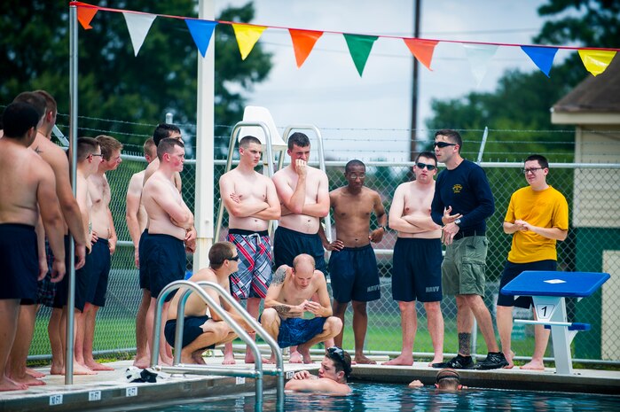 Petty Officer Braxton Smith, an instructor from the Naval Submarine School in Groton, Conn., prepares Naval Nuclear Power Training Command students for their next evolution as they practice survival techniques and receive training on using a Submarine Escape Immersion Equipment Suit July 17, 2014, at Joint Base Charleston, S.C Almost 150 enlisted NNPTC students received training on surface survival techniques and using SEIE. (U.S. Air Force photo/Senior Airman George Goslin)