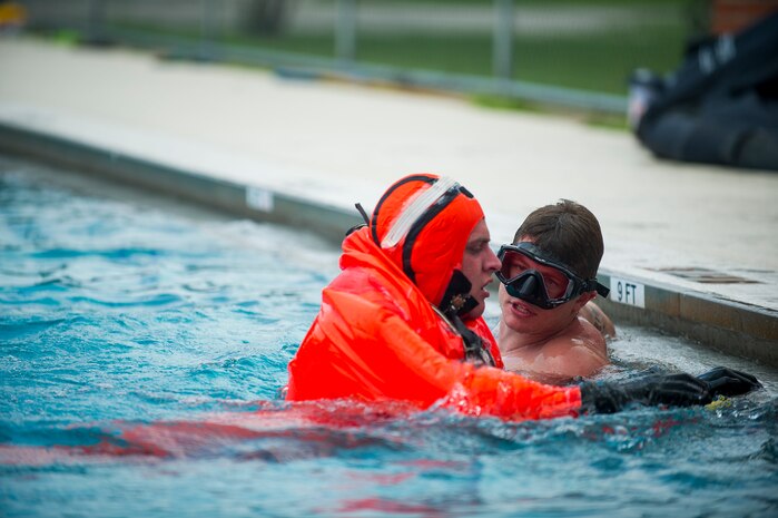 Petty Officer Toby Godwin, an instructor from the Naval Submarine School in Groton, Conn., offers words of encouragement as he assists a Naval Nuclear Power Training Command student practicing survival techniques inside a Submarine Escape Immersion Equipment suit July 17, 2014, at Joint Base Charleston, S.C Almost 150 enlisted NNPTC students received training on surface survival techniques and using SEIE. (U.S. Air Force photo/Senior Airman George Goslin)