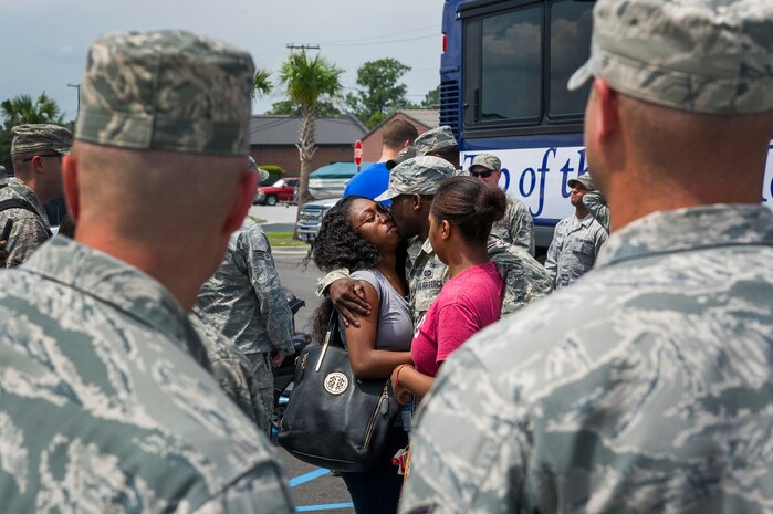 Senior Airman Radonte Bennett, 628th Civil Engineer Squadron structures journeyman, kisses his wife Ka'Shia before deployment to Guantanamo Bay, Cuba, July 17, 2014, at Joint Base Charleston, S.C. Members of the 628th CES deployed to Guantanamo Bay for installation support. (U.S. Air Force photo/Senior Airman George Goslin)