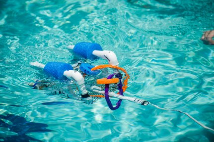 A SeaPerch submarine moves through the water with a ring, July 18, 2014, at Joint Base Charleston, S.C. The teams competed by using their submarines to pick up rings in the pool. (U.S. Air Force photo/Senior Airman George Goslin)