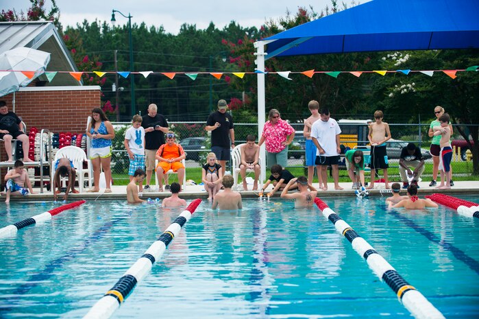Dependent children immerse their SeaPerch submarines into a pool for a team based competition, July 18, 2014, at Joint Base Charleston, S.C. The teams competed by using their submarines to pick up rings in the pool. (U.S. Air Force photo/Senior Airman George Goslin)