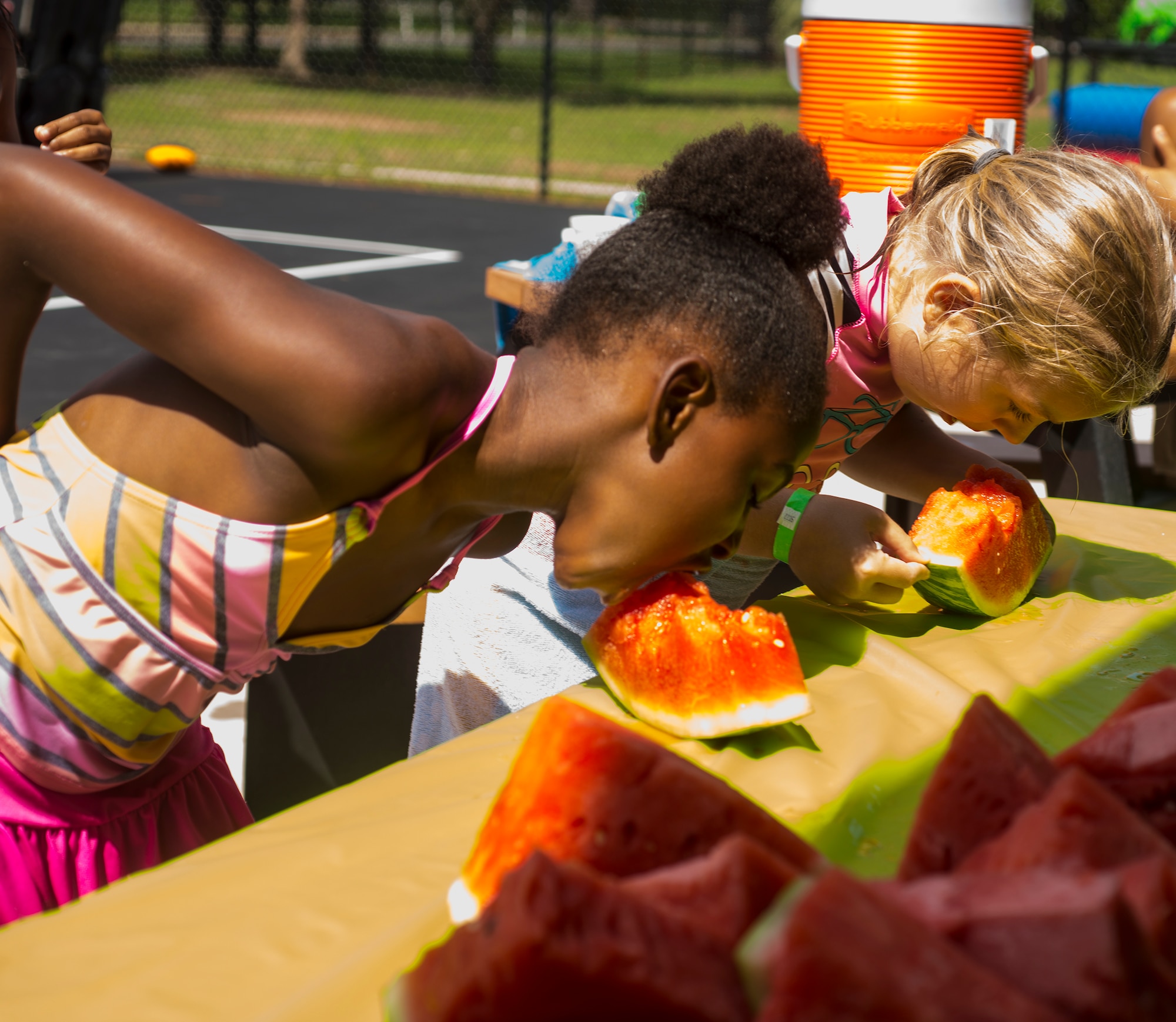 Taunya Thompson, left and Janay Hill, compete in a watermelon eating contest during the July Jamboree at Moody Air Force Base, Ga., July 22, 2014. Each contestant had to eat the watermelon as fast as possible without using their hands. (U.S. Air Force photo by Airman 1st Ceaira Tinsley/Released)