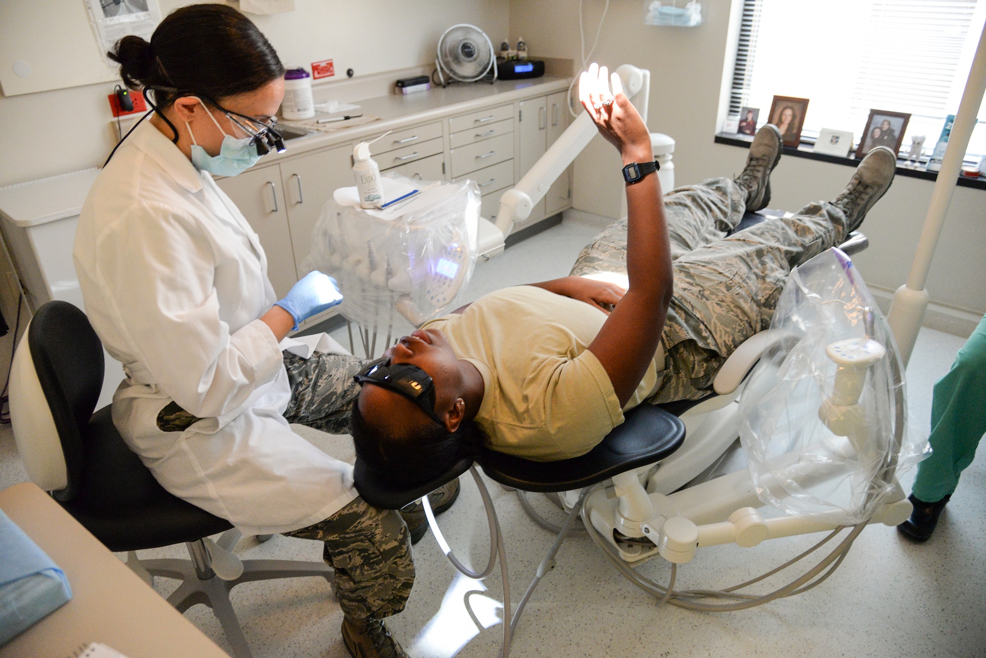 U.S. Air Force Capt. (Dr.) Jamie Smith, 23d Aeromedical Dental Squadron dentist, uses cold stimulation to check for nerve damage on Airman 1st Class Ceaira Tinsely, 23d Wing public affairs photojournalist at Moody Air Force Base, Ga., July 22, 2014. Smith instructed Tinsley to raise her hand at the first sign of pain. (U.S. Air Force photo by Airman 1st Class Sandra Marrero/Released)
