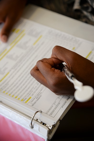 U.S. Air Force Airman 1st Class Ceaira Tinsely, 23d Wing public affairs photojournalist, signs into the dental clinic at Moody Air Force, Ga., July 22, 2014. Tinsley visited the clinic for tooth pain and sensitivity. (U.S. Air Force photo by Airman 1st Class Sandra Marrero/Released) 
