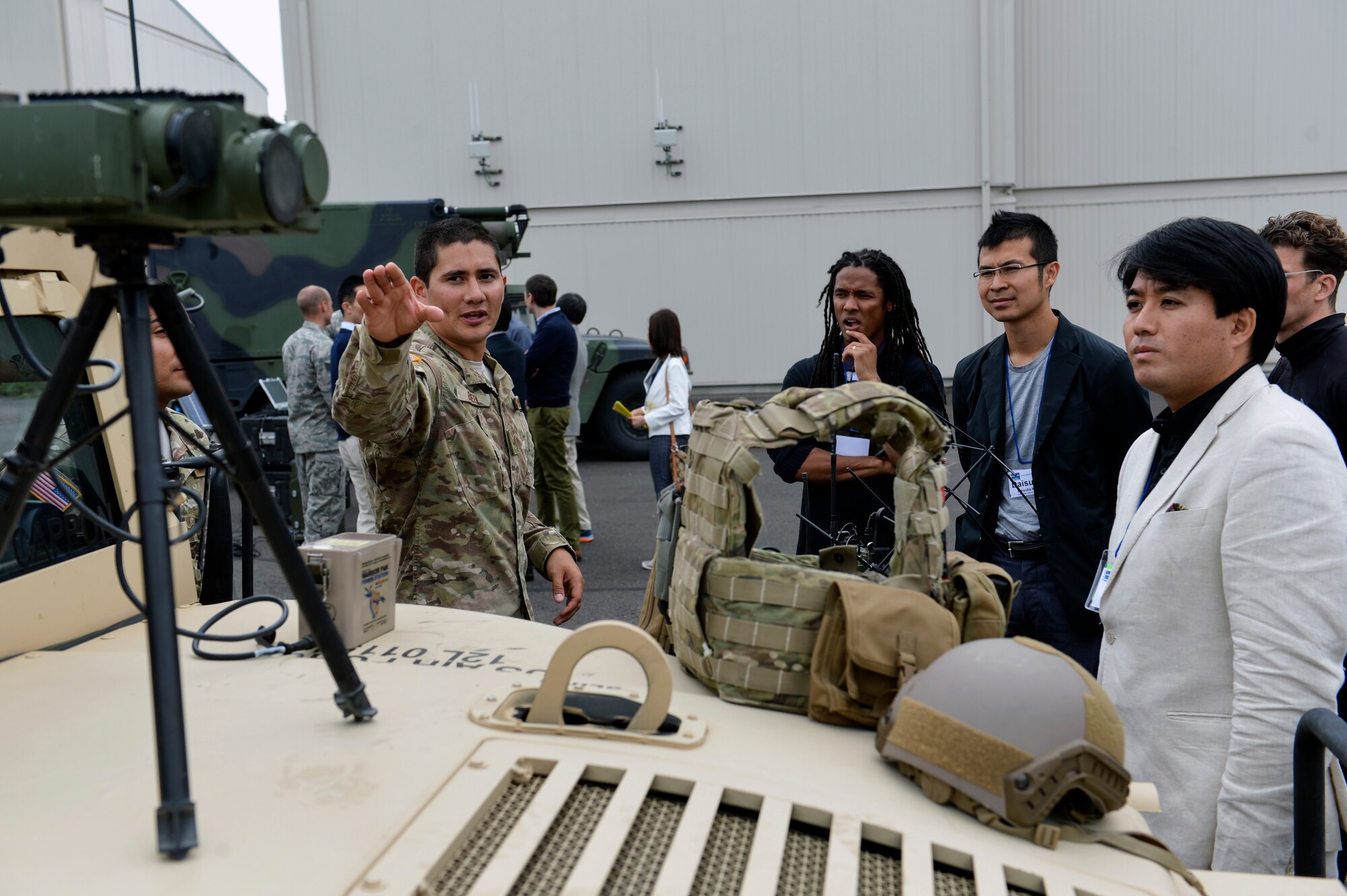 Staff Sgt. Edward Breen Jr., 5th Air Support Operations Squadron tactical air control party member, displays a laser designator mounted on a high multipurpose wheeled vehicle July 22, 2014, to members of the U.S. Japan Leadership Program at Joint Base Lewis-McChord. The USJLP brings approximately 20 young leaders together from each country for discussions revolving around historical and current issues in bilateral relations, as well as issues reaching beyond the two countries. (U.S. Air Force photo/Staff Sgt. Russ Jackson)