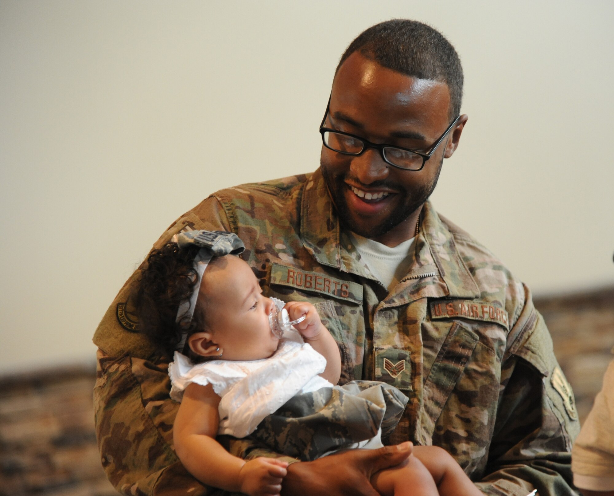 Senior Airman Clearion Roberts, a member of the 341st Civil Engineer Squadron deployed to Southwest Asia, holds his child for the first time at Great Falls International Airport, Great Falls, Mont., July 22. Sixteen members from 341 st CES returned home after a six-month deployment. (U.S. Air Force photo/Airman 1st Class Joshua Smoot)