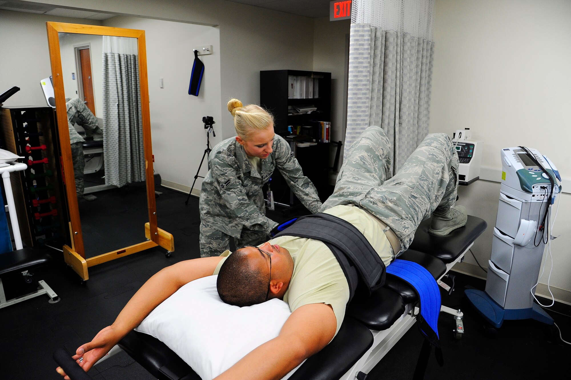 Airman 1st Class Kaitlyn Arteaga, 341st Medical Group physical therapy technician demonstrates the use of a pelvic traction machine, which helps patients with back and or neck pain. Traction is used to stretch the spine, releasing any tension or pressure on the spine, and may be used in conjunction with exercises to help ease pain, as well as other symptoms. (U.S. Air Force photo/Airman 1st Class Collin Schmidt)