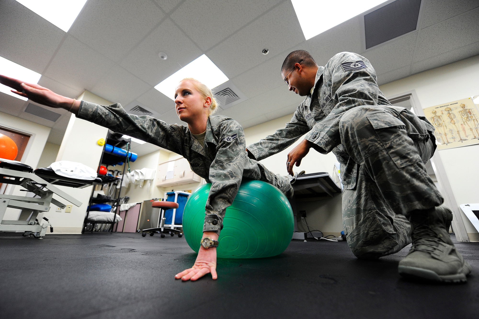 Airman 1st Class Kaitlyn Arteaga, 341st Medical Group physical therapy technician (left), and Tech. Sgt Hugo Reinor, 341st MDG physical therapy technician, demonstrate the practice of a common core stabilization exercise performed in the physical therapy clinic. Core stabilization exercises strengthen the abdominal core muscles, which support and align the spine in its correct neutral position. (U.S. Air Force photo/Airman 1st Class Collin Schmidt)
