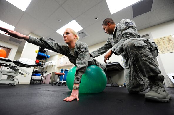 Airman 1st Class Kaitlyn Arteaga, 341st Medical Group physical therapy technician (left), and Tech. Sgt Hugo Reinor, 341st MDG physical therapy technician, demonstrate the practice of a common core stabilization exercise performed in the physical therapy clinic. Core stabilization exercises strengthen the abdominal core muscles, which support and align the spine in its correct neutral position. (U.S. Air Force photo/Airman 1st Class Collin Schmidt)