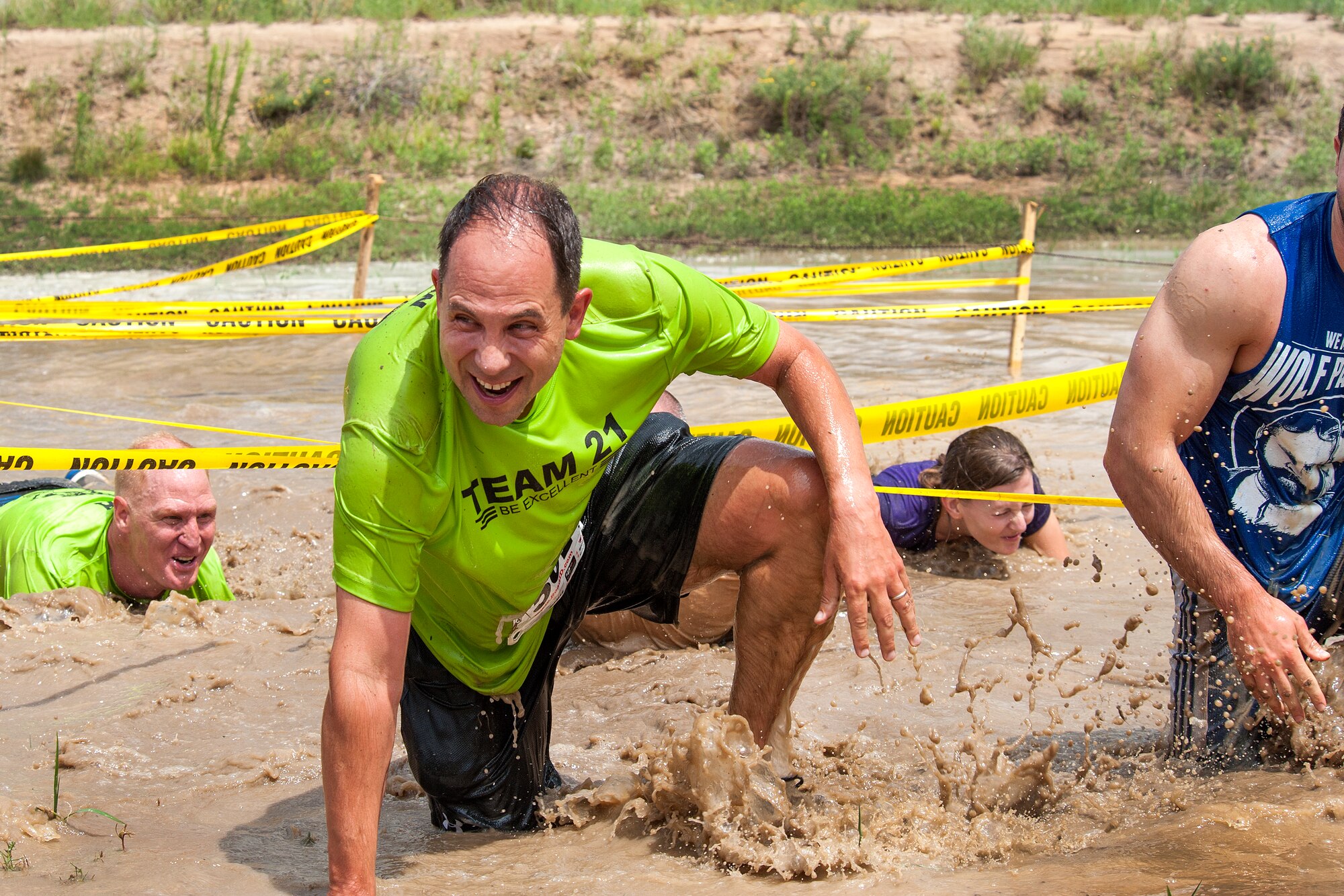 PETERSON AIR FORCE BASE, Colo. – Col. John Shaw, 21st Space Wing commander, crawls out of the mud during “Wacky Warfit” July 26 here. Warfit is monthly and is normally a 5K run. This month, however, was “Wacky”, so the length was increased to 3.25 miles and comprised of nine obstacles, including mud pits, water hazards and barriers. (U.S. Air Force photo/ Craig Denton)