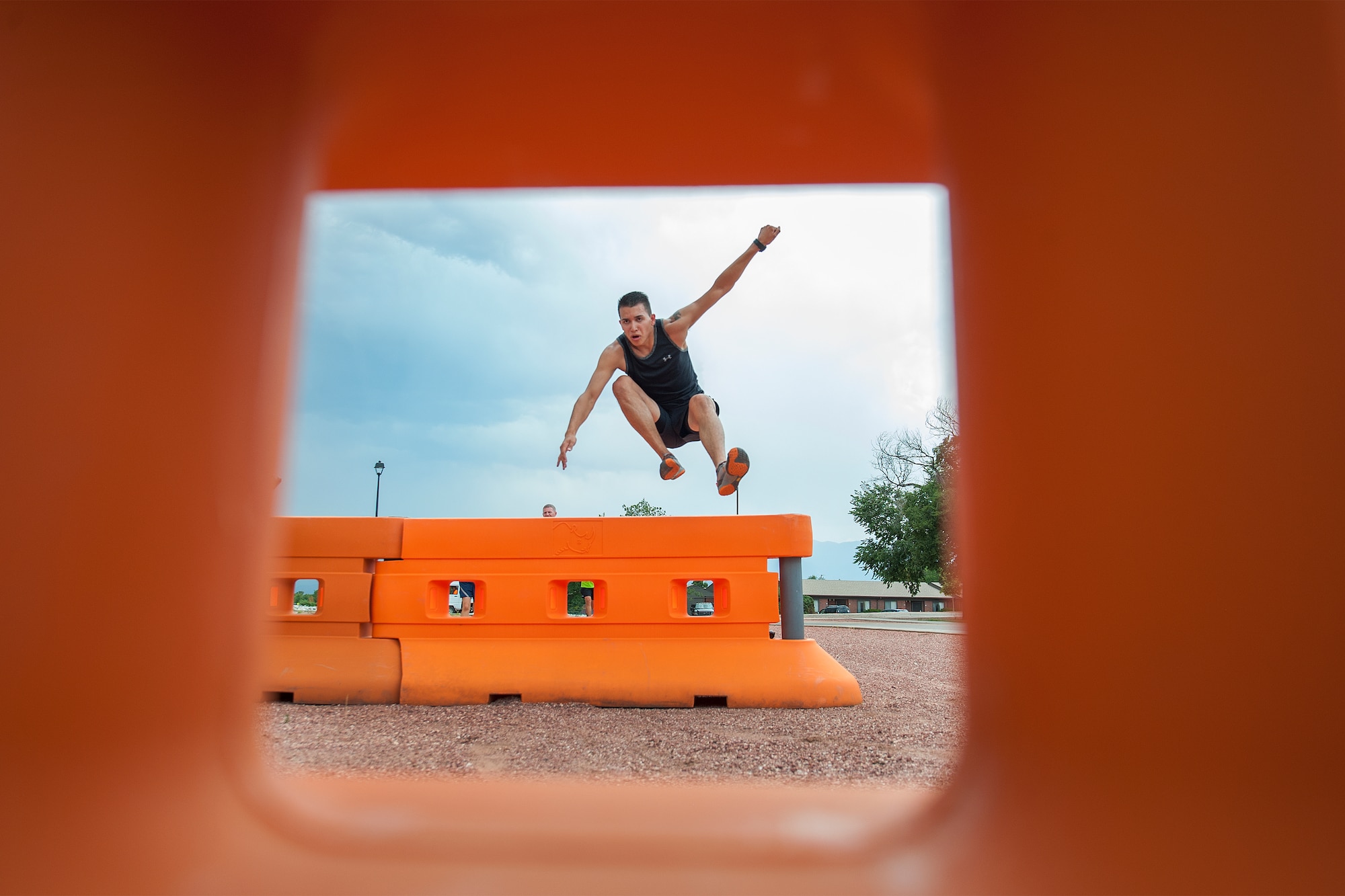 PETERSON AIR FORCE BASE, Colo. – Airman 1st Class Javier Ruiz, 21st Communications Squadron, hurdles an obstacle during “Wacky Warfit” July 26 here. Warfit is monthly and is normally a 5K run. This month, however, was “Wacky,” so the length was increased to 3.25 miles and comprised of nine obstacles, including mud pits, water hazards and barriers. Ruiz and his team the “Honey Badgers” won the event with a time of 30 minutes, 22 seconds. (U.S. Air Force photo/ Craig Denton)