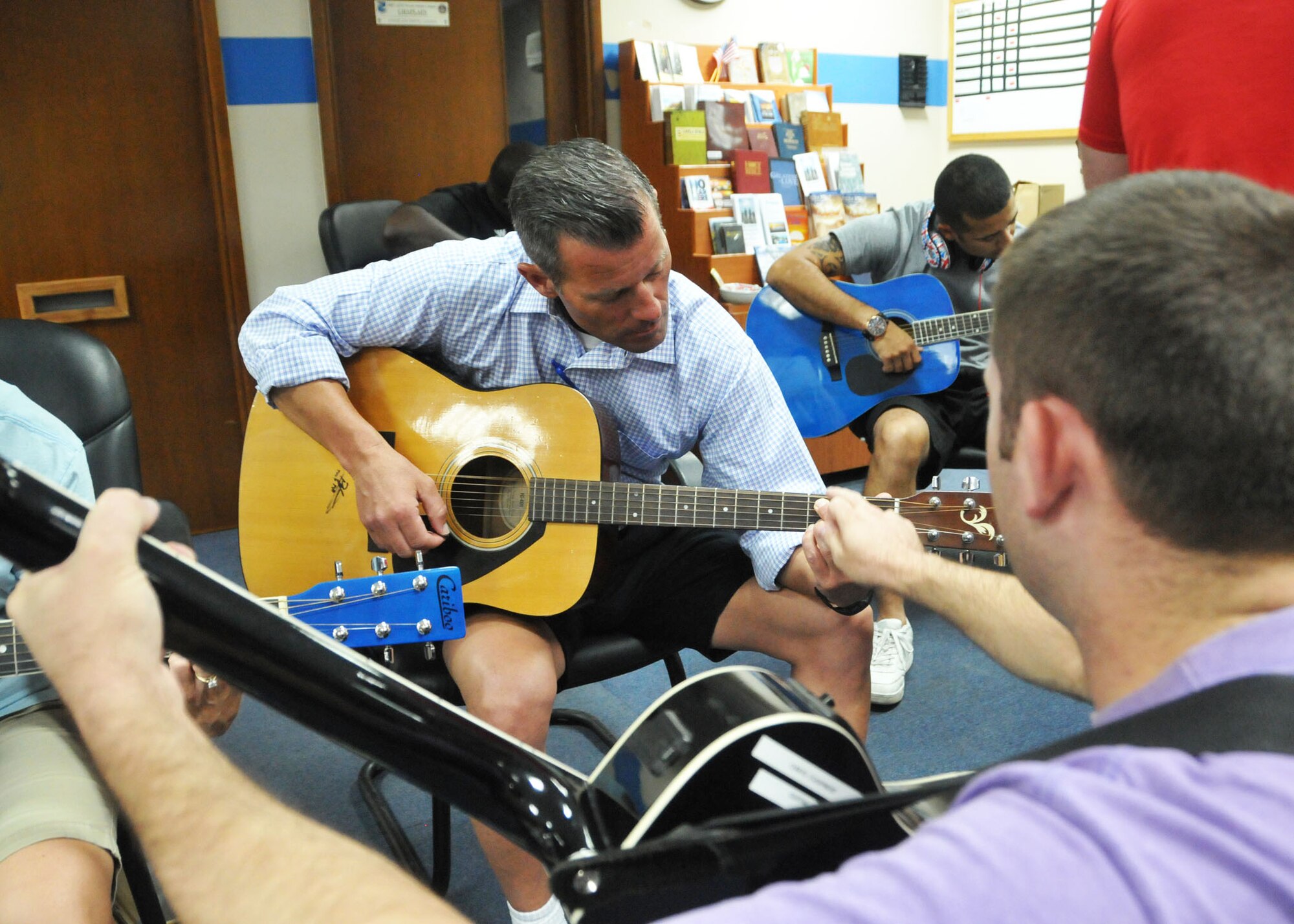 Air Force Capt. Jared Bueche shows Chaney Ferguson, 380th Air Expeditionary Wing’s community and recreation services flight chief, the correct fingering of a chord during his guitar class. Ferguson was one of 15 students who signed up for the beginning guitar course offered to individuals serving at the wing’s undisclosed location in Southwest Asia. (U.S. Air Force photo by Senior Master Sgt. Eric Peterson/Released)