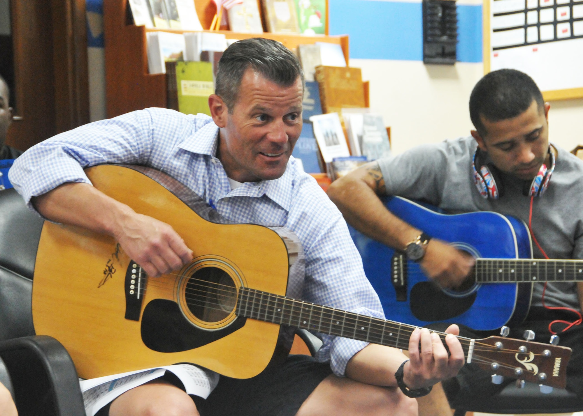 Chaney Ferguson, 380th Air Expeditionary Wing’s community and recreation services flight chief, strums his guitar during a guitar class taught at the wing chapel July 16, 2014. Ferguson was one of 15 students who signed up for the beginning guitar course offered to individuals serving at the wing’s undisclosed location in Southwest Asia. (U.S. Air Force photo by Senior Master Sgt. Eric Peterson/Released)