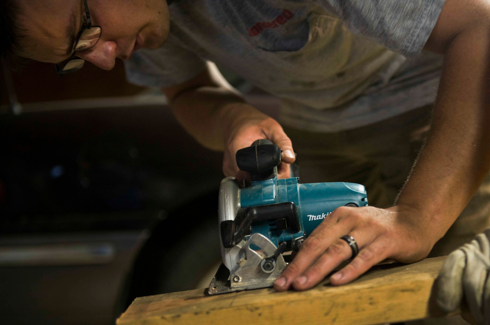 Senior Airman Jacob Blankenbaker, 5th Civil Engineer Squadron structural journeyman, saws through a wooden board during a volunteer project in Velva, N.D., July 28, 2014. The 5th CES volunteers helped rebuild the home of a Minot native who lost his possessions in the 2011 flood. (U.S. Air Force photo/Airman 1st Class Lauren Pitts) 