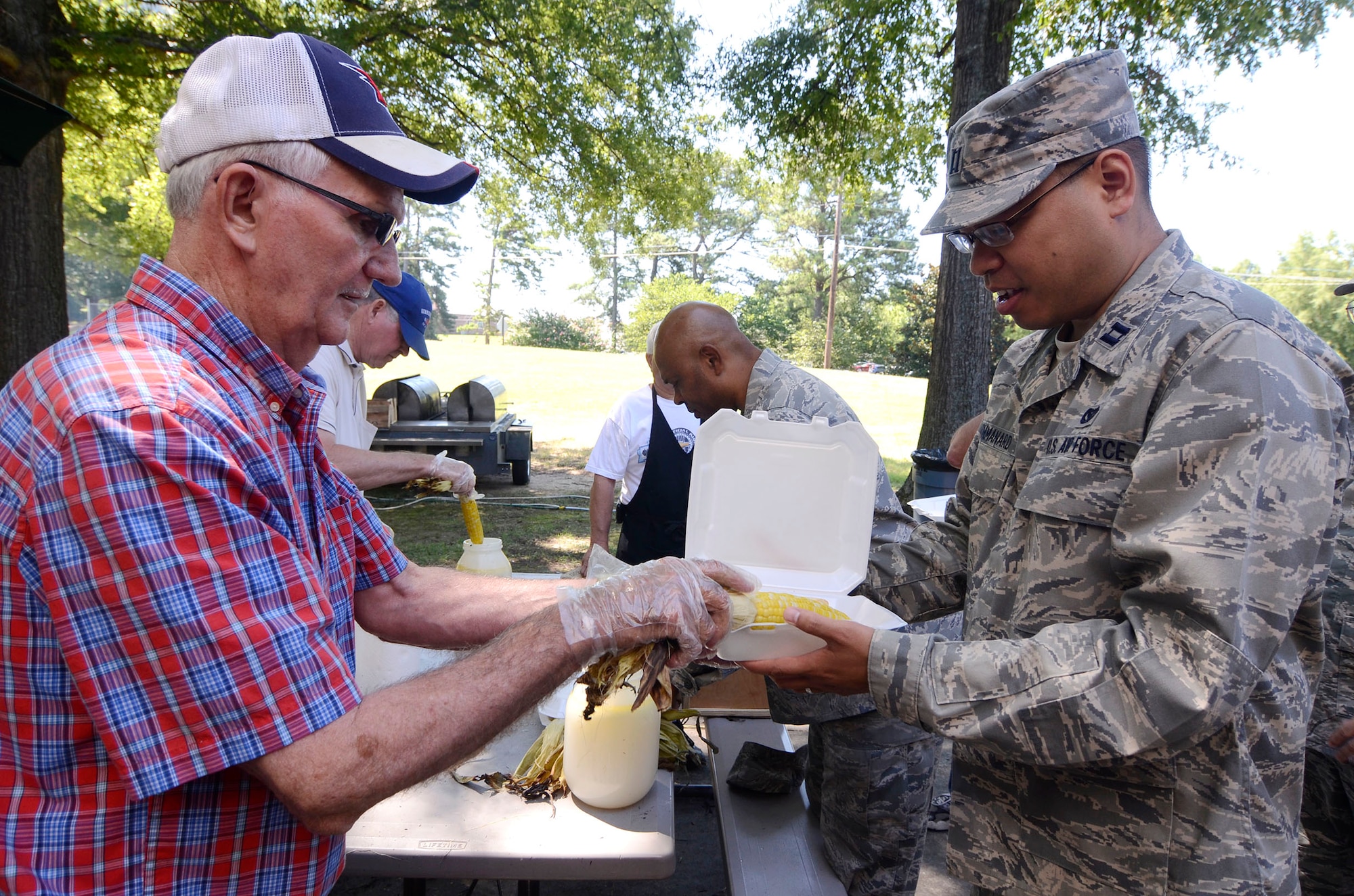 Tommy Wiggington, serves up ears of corn to those attending the 10th annual Corn N’ Sausage Roast held on Dobbins Air Reserve Base, Ga. July 16, 2014. The events proceeds are donated to the Airman and Family Readiness Emergency Fund. (U.S. Air Force photo/Don Peek)