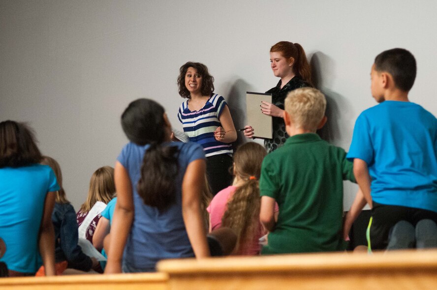 Sarah Feinmark, left, and Kristina Kirkham, right, tour directors and actors with the Missoula Children's Theater, instruct base children during auditions for a production of Beauty Lou & The Country Beast at the Hanscom Air Force Base Theater July 21. Two free showings of the production are scheduled at 10 a.m. and 2 p.m. July 26 at the theater. (U.S Air Force Photo by Mark Herlihy)