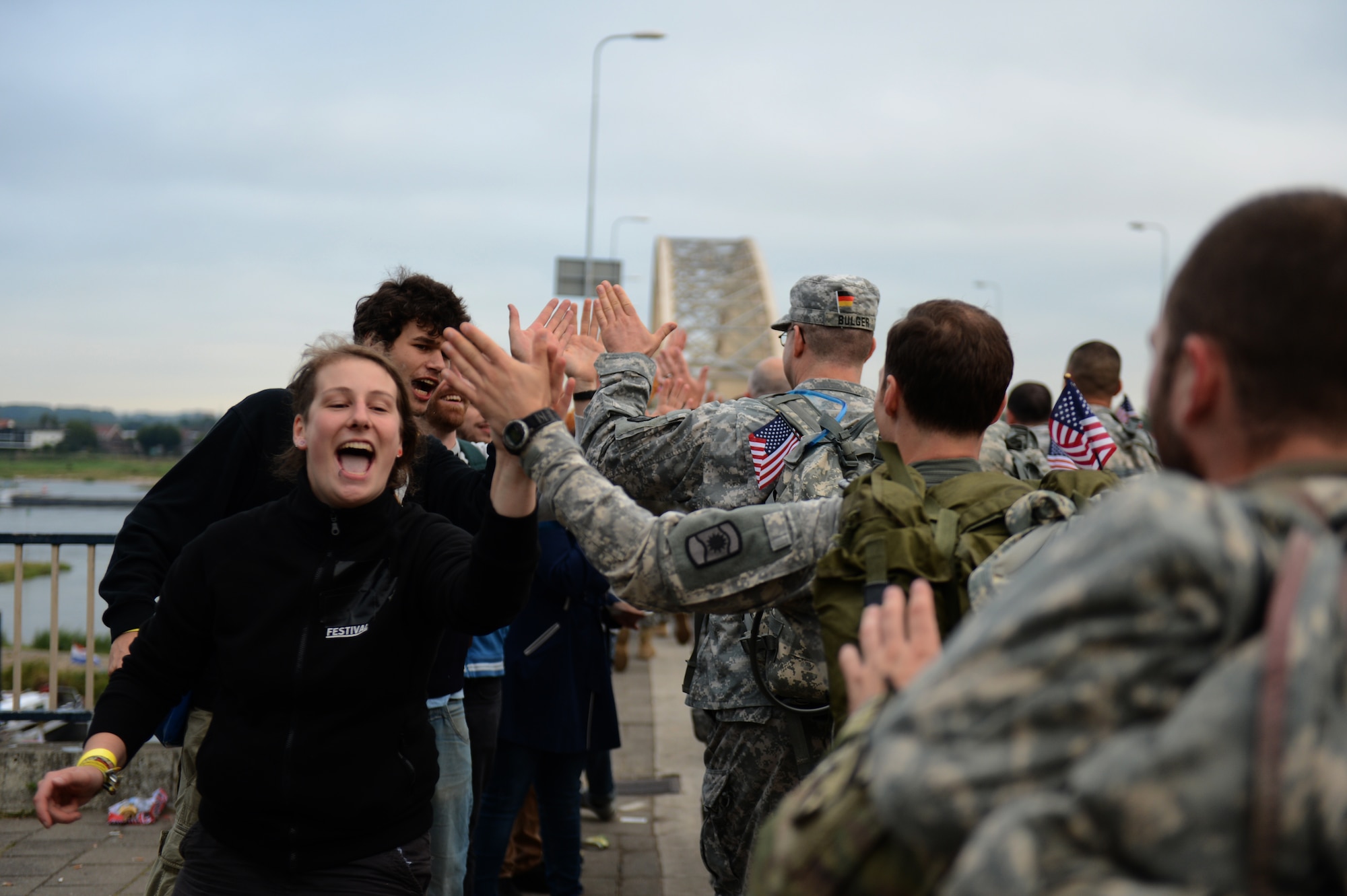 Spectators greet International Four Days Marches Nijmegen participants from the U.S. Army 361st Civil Affairs Brigade and U.S. Air Force 52nd Fighter Wing before crossing a bridge in Nijmegen, Netherlands, July 15, 2014. Spectators in every town along the route filled the street cheering on the march participants. (U.S. Air Force photo by Senior Airman Gustavo Castillo/Released)