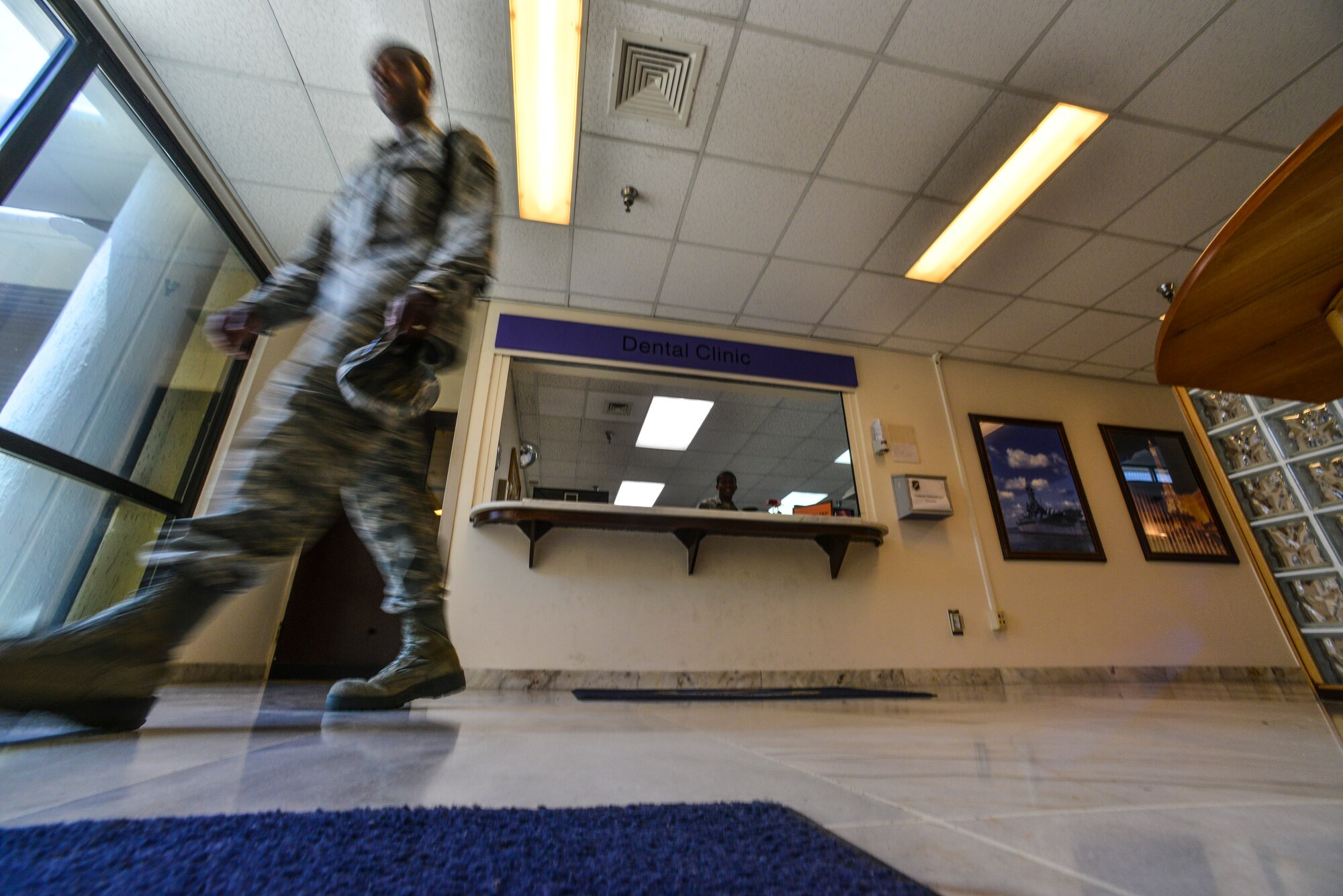 An Airman exits the 39th Medical Group after visiting the dental clinic July 22, 2014, Incirlik Air Base, Turkey. The 39th MDG dental clinic supports active duty service members at Incirlik AB, Izmir Air Station and 717th Air Base Squadron in Ankara, Turkey.  (U.S. Air Force photo by Senior Airman Nicole Sikorski/Released)
