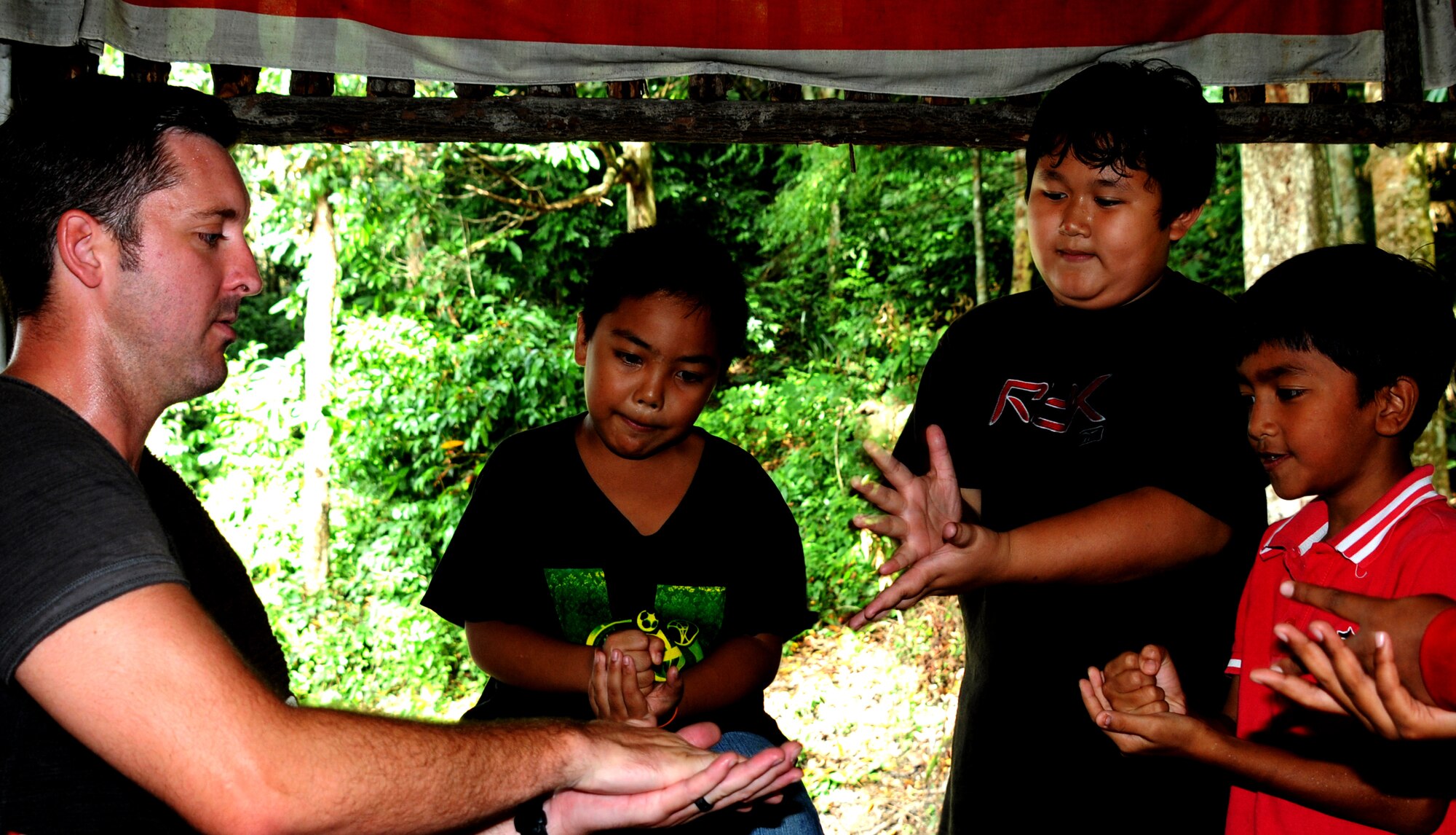 Tech. Sgt. Jesse Richardson, from the 535th Airlift Squadron in Hickam Air Force Base, Hawaii, plays games with the children during a community outreach visit to Pondok Penyayang Raudhah orphanage in Kuala Lumpur, Malaysia, June 14, 2014.  The 353rd Special Operations Group, alongside participants from Pacific Air Forces Exercise Cope Taufan 2014, came together to raise over $1,000 in supplies for the orphanage.  The two groups donated their time to help with small repairs and yard cleanup around the orphanage in addition to visiting with the children.  (U. S. Air Force photo by Tech. Sgt. Kristine Dreyer)