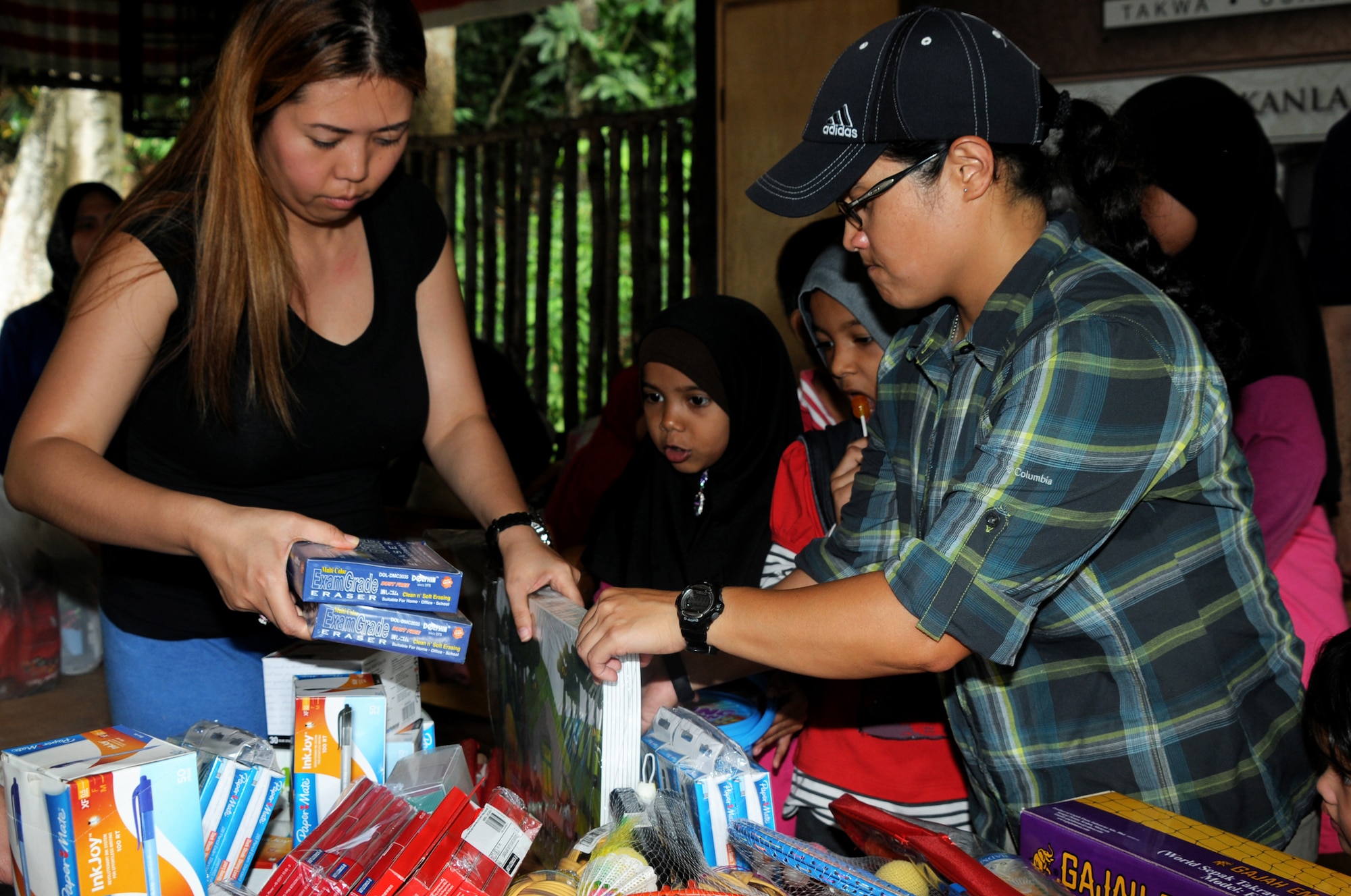 Tech. Sgt. Karla Brown, 353rd Special Operations Maintenance Squadron, and Capt. (Dr.) MaryRose Chuidian, 353rd Special Operations Support Squadron sort supplies during a community outreach visit to  Pondok Penyayang Raudhah orphanage in Kuala Lumpur, Malaysia, June 14, 2014.  The 353rd Special Operations Group, alongside participants from Pacific Air Forces Exercise Cope Taufan 2014, came together to raise over $1,000 in supplies for the orphanage.  The two groups donated their time to help with small repairs and yard cleanup around the orphanage in addition to visiting with the children.  (U. S. Air Force photo by Tech. Sgt. Kristine Dreyer)