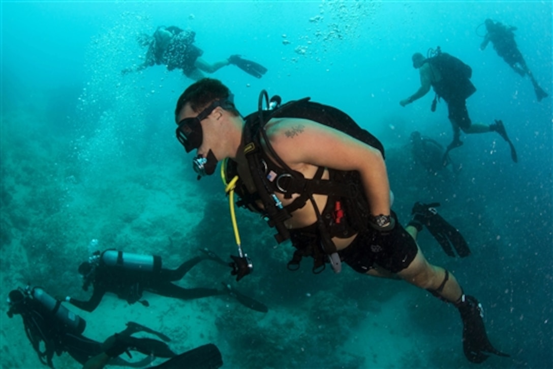 U.S. Navy Petty Officer 2nd Class Brent Draper, foreground, and other divers assigned to Mobile Diving and Salvage Unit 2, dive with Belize coast guard members at Belize's Blue Hole in the Caribbean Sea, July 13, 2014. The divers are participating in Southern Partnership Station 2014, which focuses on subject matter expert exchanges with partner nation forces. 