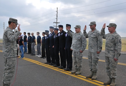 Lt. Gen. Stanley E. Clarke III, the director of the Air National Guard, administers the oath of enlistment during a mass re-enlistment ceremony, for Airmen of the 153rd Airlift Wing on July 23, 2014. Clarke visited the 153rd, and met with unit and Wyoming National Guard leaders .